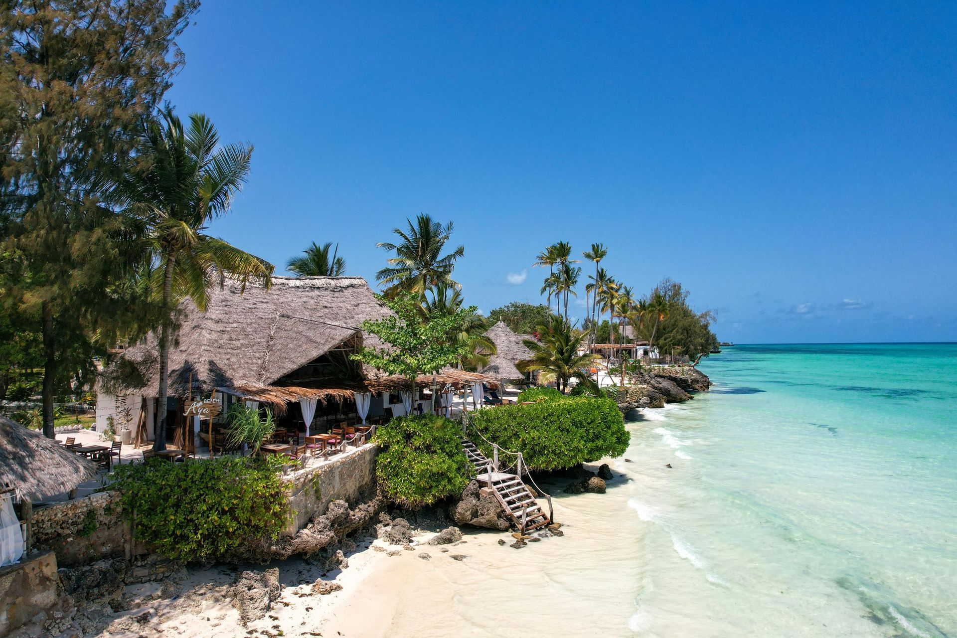 A tropical beach with a hut and palm trees on Zanzibar island in Tanzania, Africa.