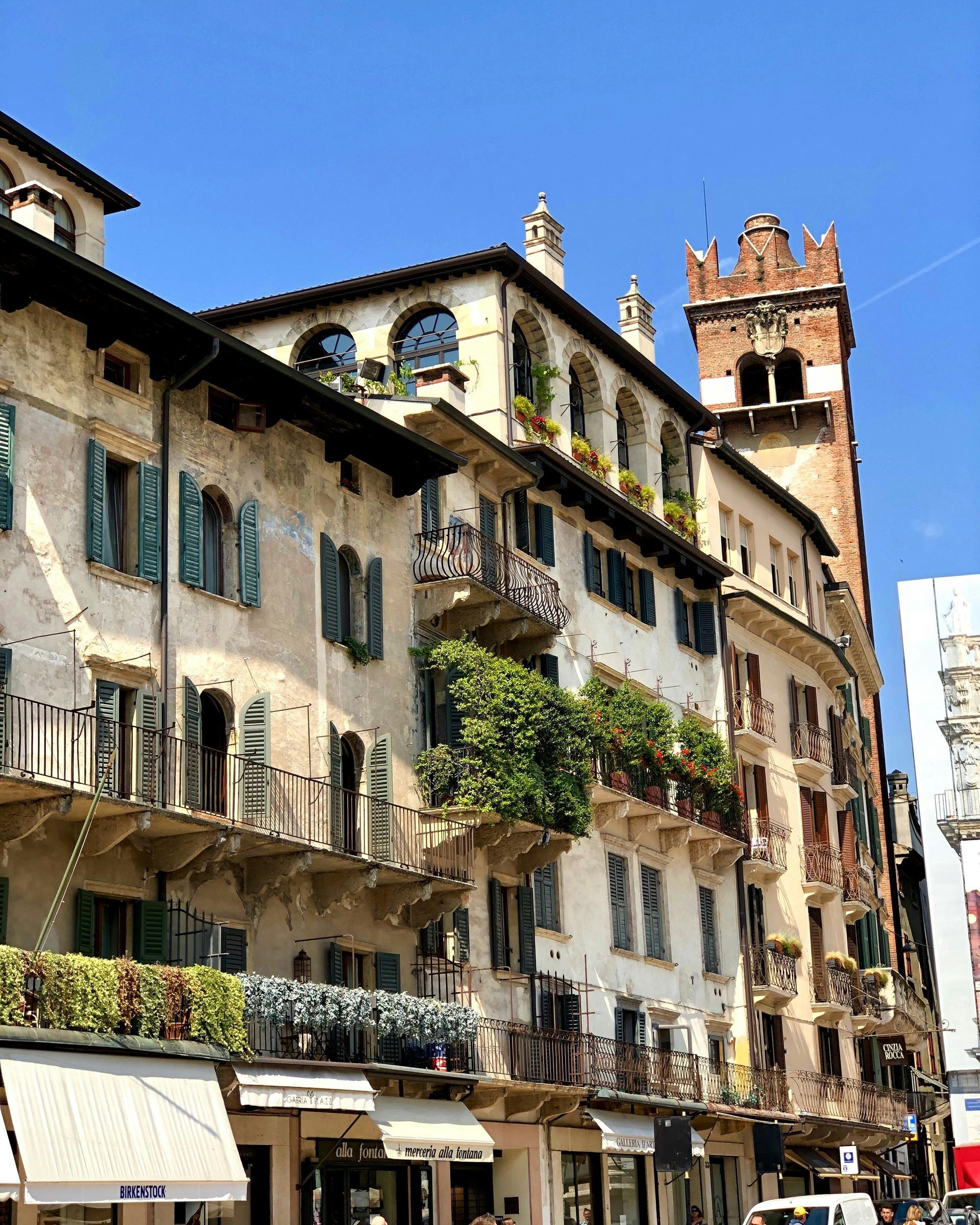 A large building with a clock tower on top of it in Verona, Italy.