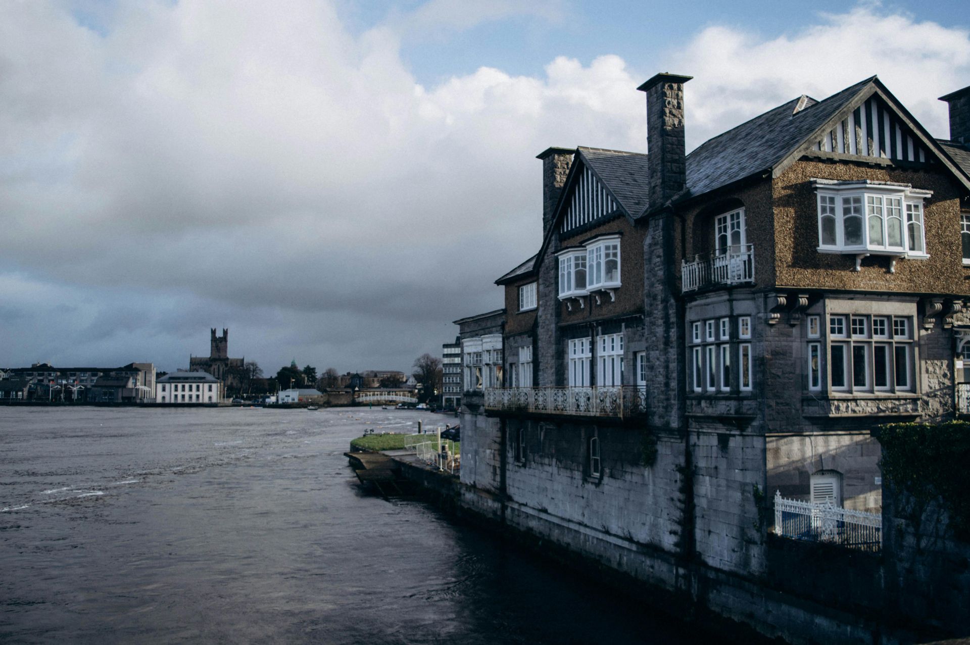 A large house is sitting next to a body of water in Limerick, Ireland.