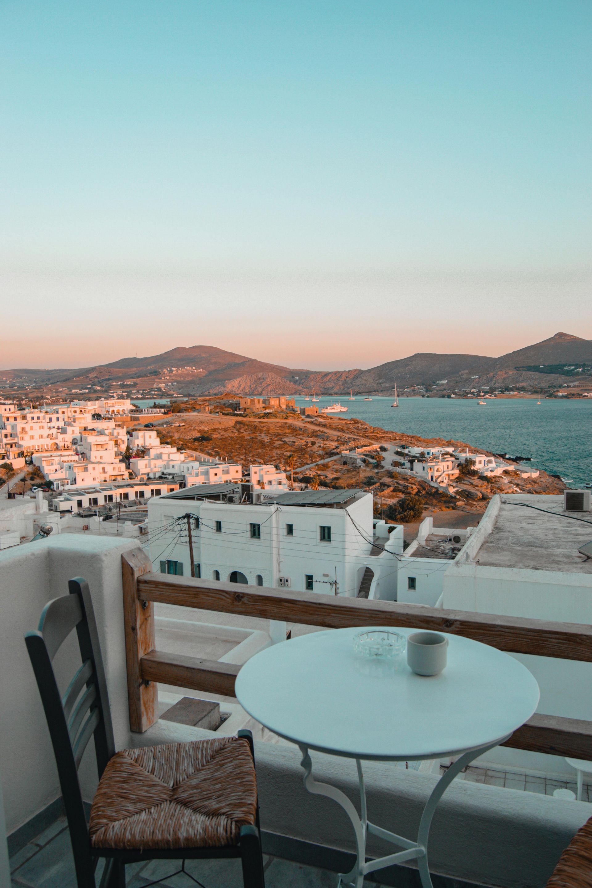 A table and chairs on a balcony overlooking the ocean in Paros, Greece.