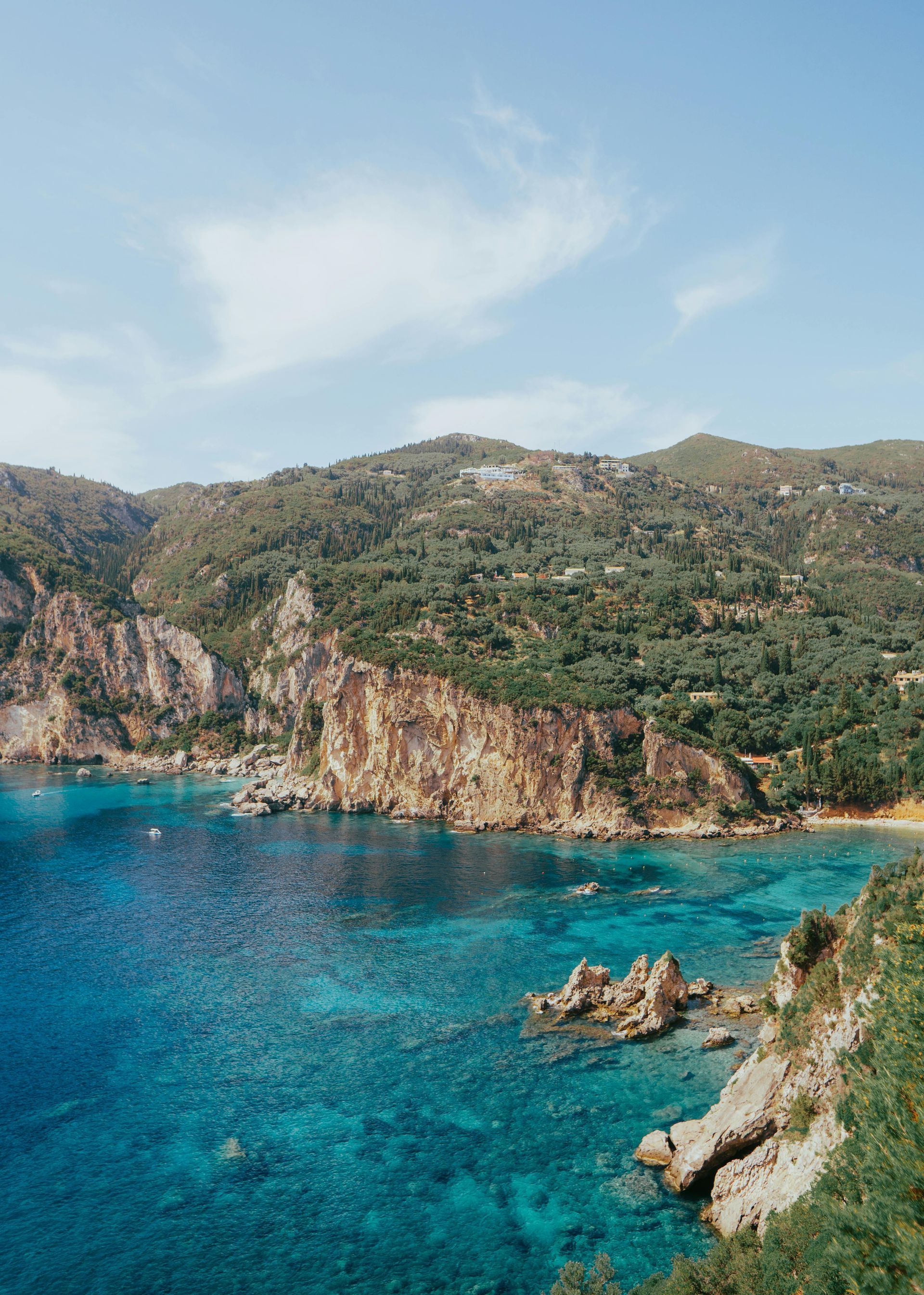 A large body of water surrounded by mountains and trees in Corfu, Greece.