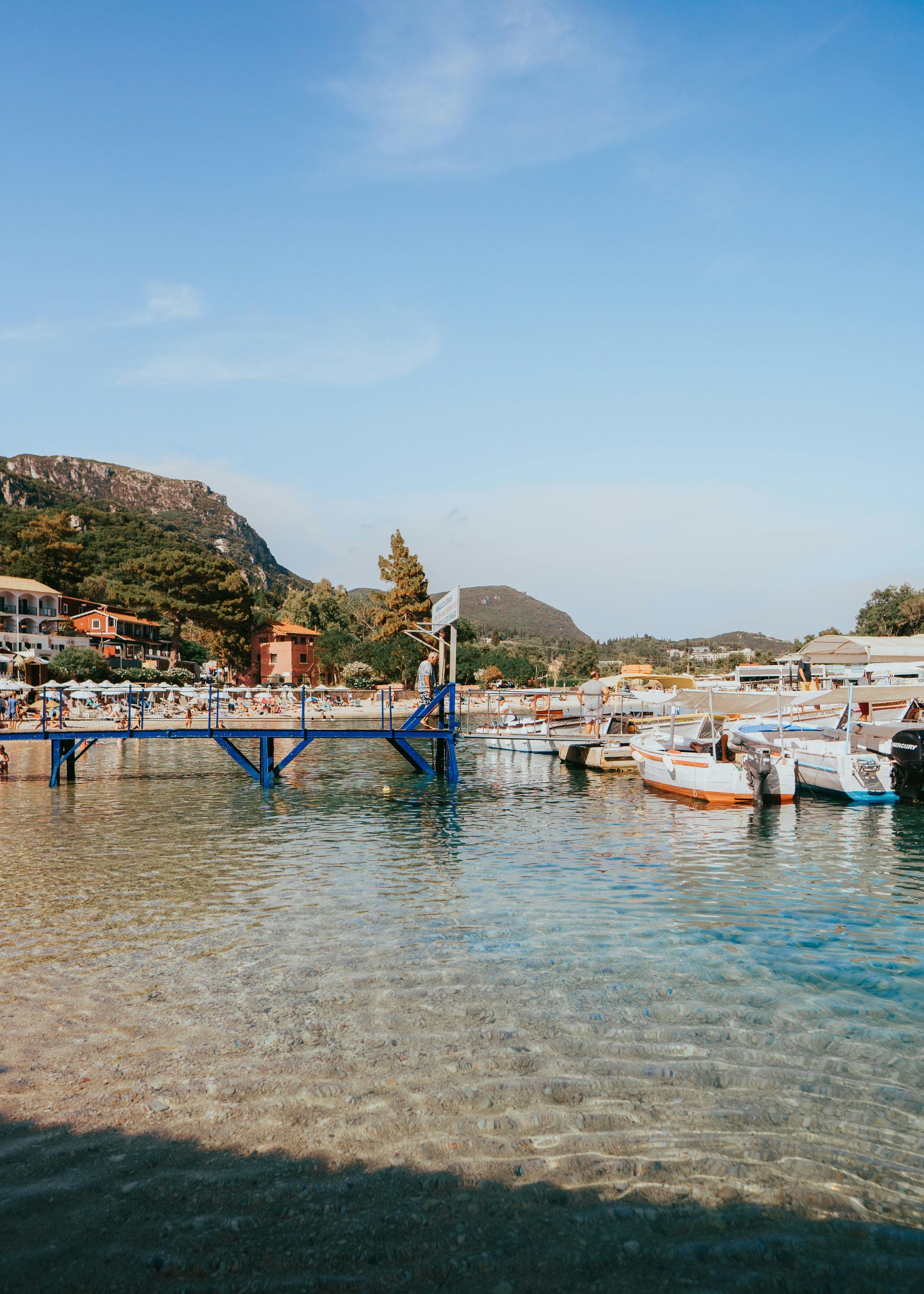 A bridge over a body of water with boats docked in it in Corfu, Greece.