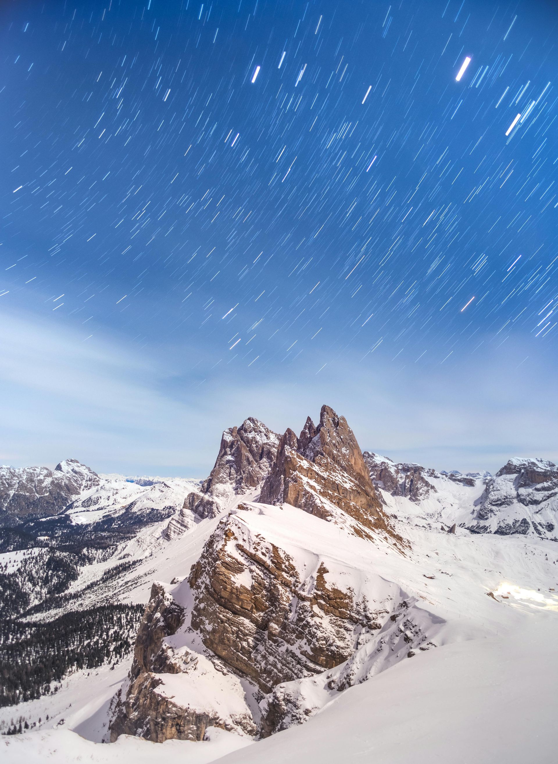 A snowy mountain with a starry sky in the background in The Dolomites in Italy,