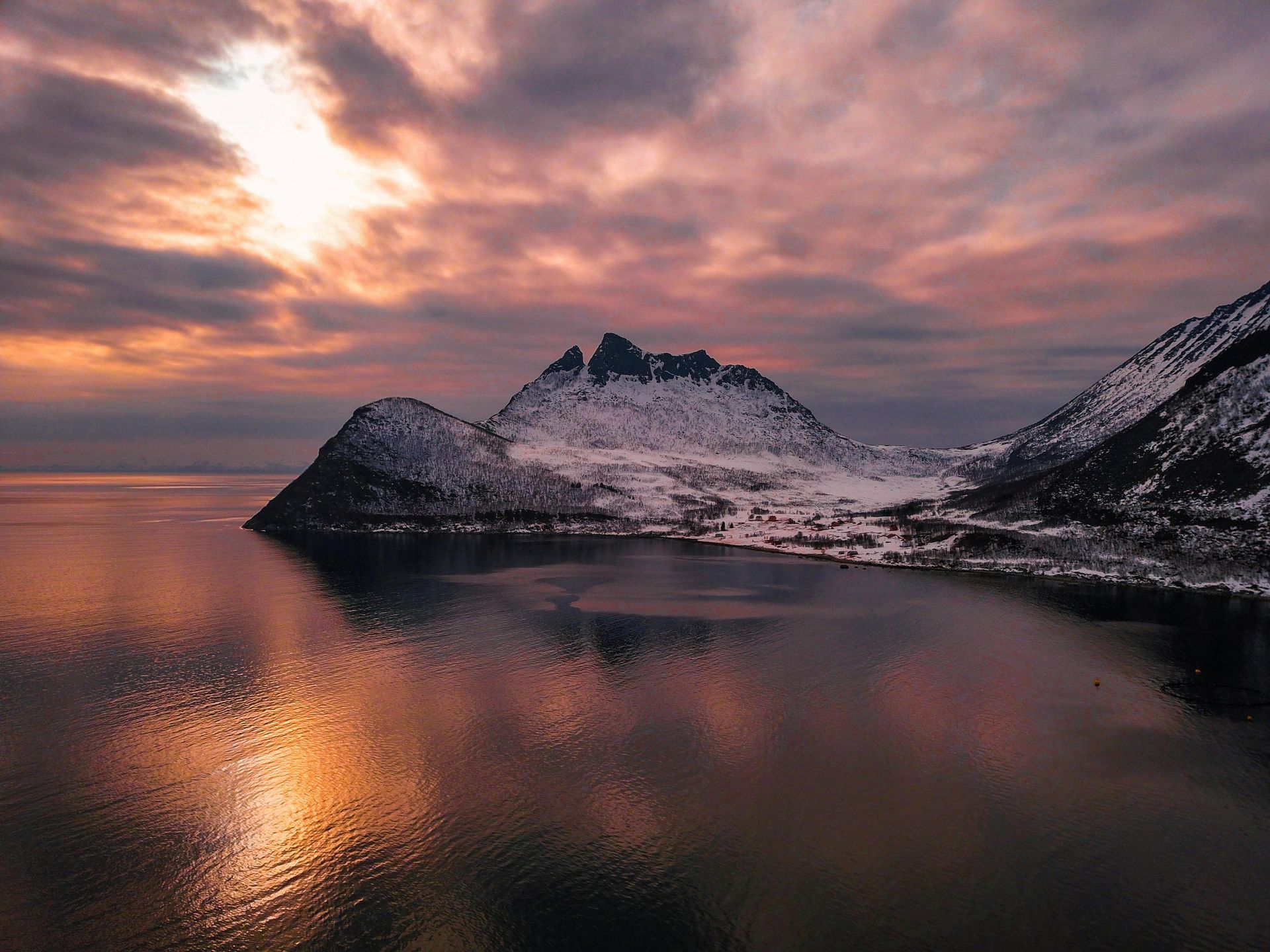 A sunset over a lake with mountains in the background on the Norwegian Coast.