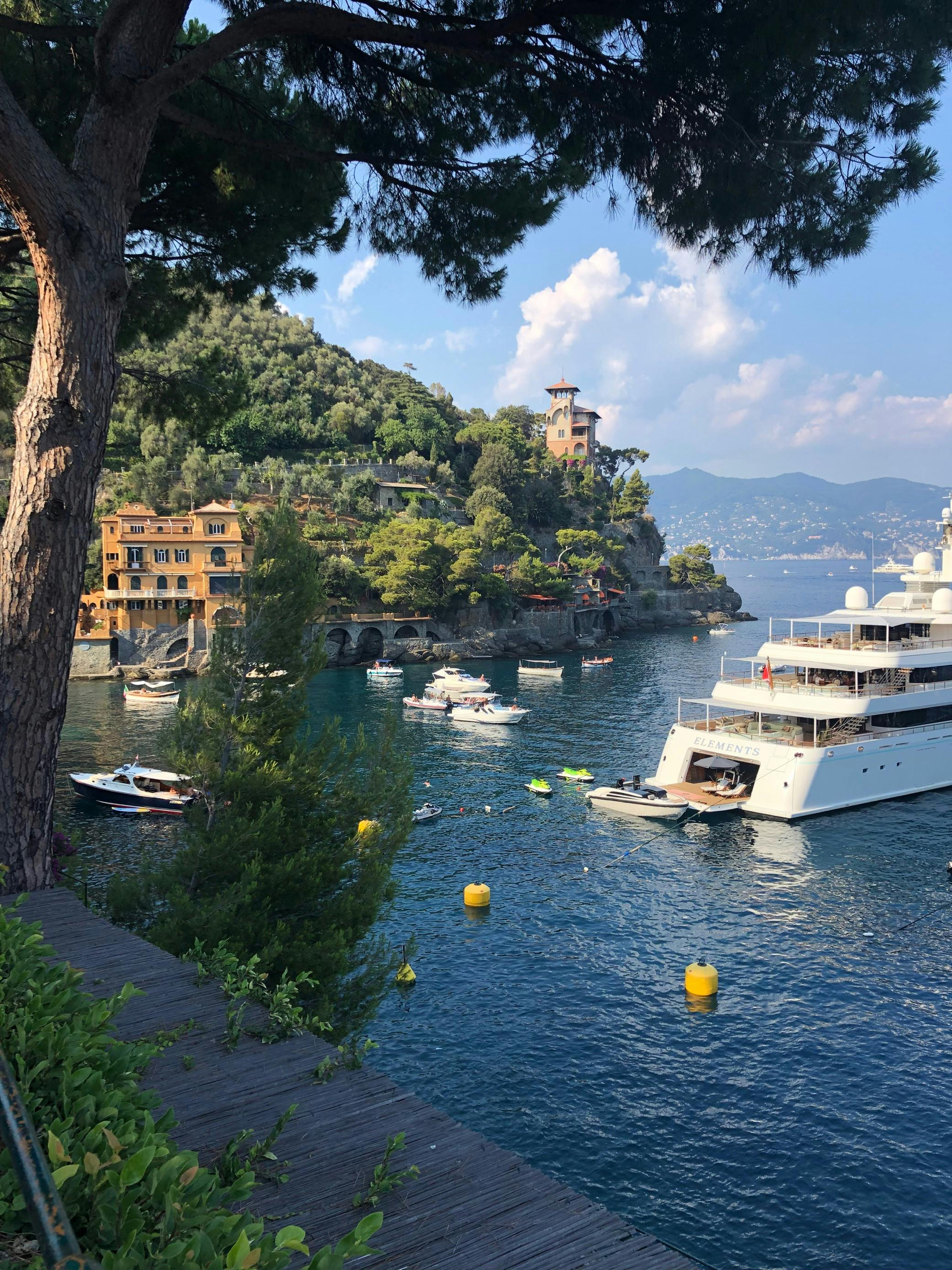 A large white yacht is docked in a body of water in Portofino, Italy.