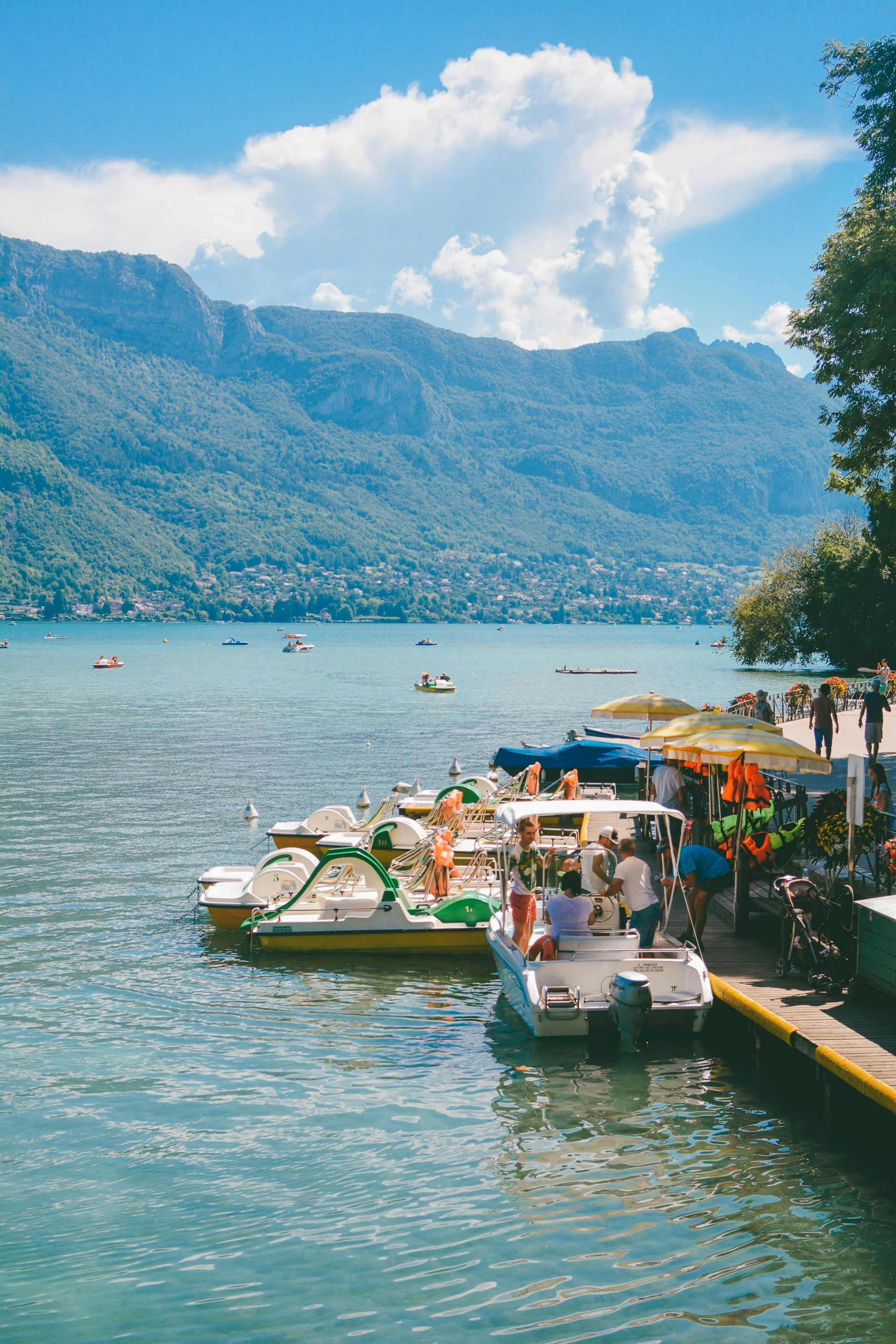 A group of boats are docked at a dock on lake Annecy in Annecy, France.