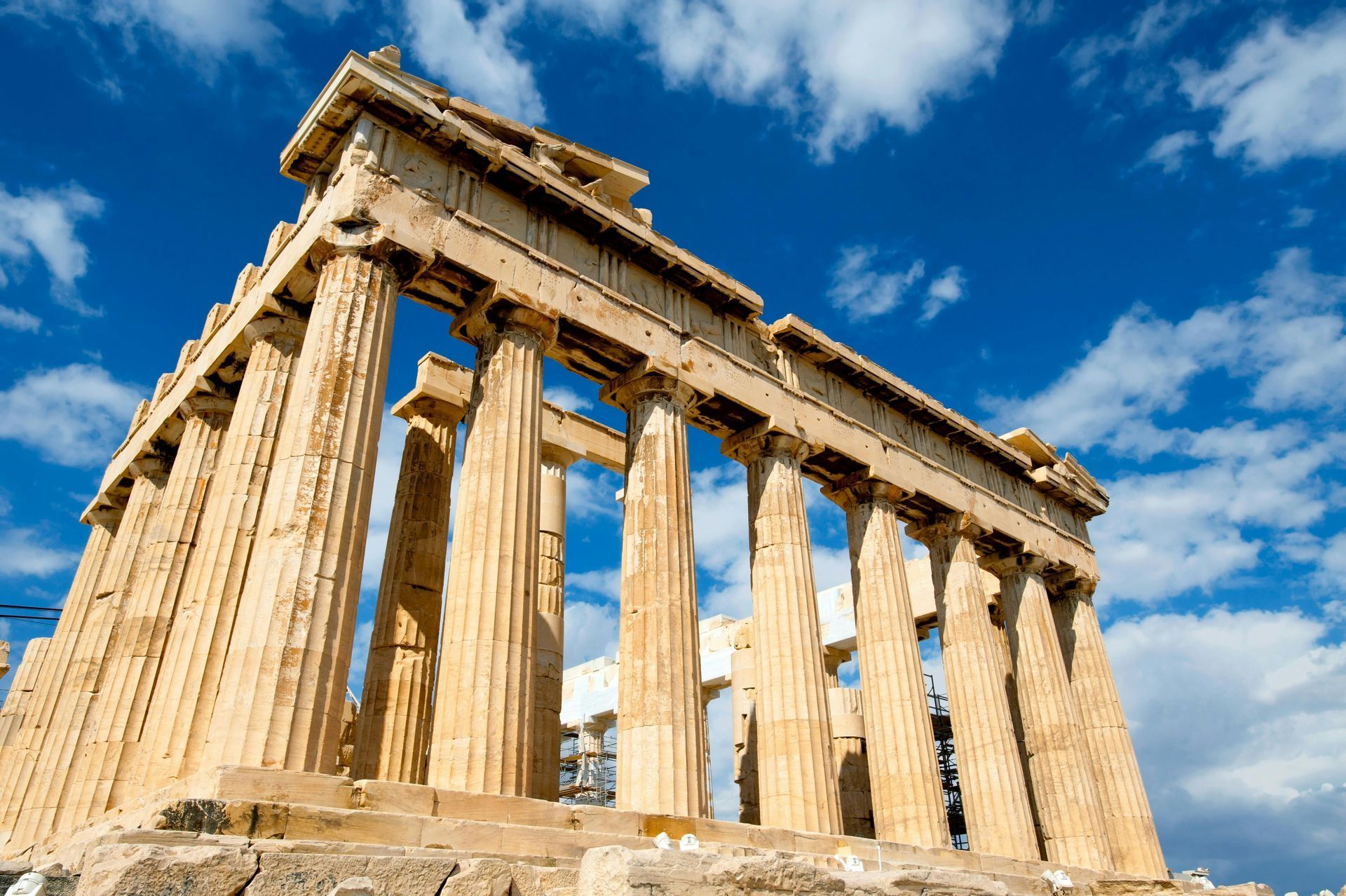 A very old building with columns and a blue sky in the background in Athens, Greece.