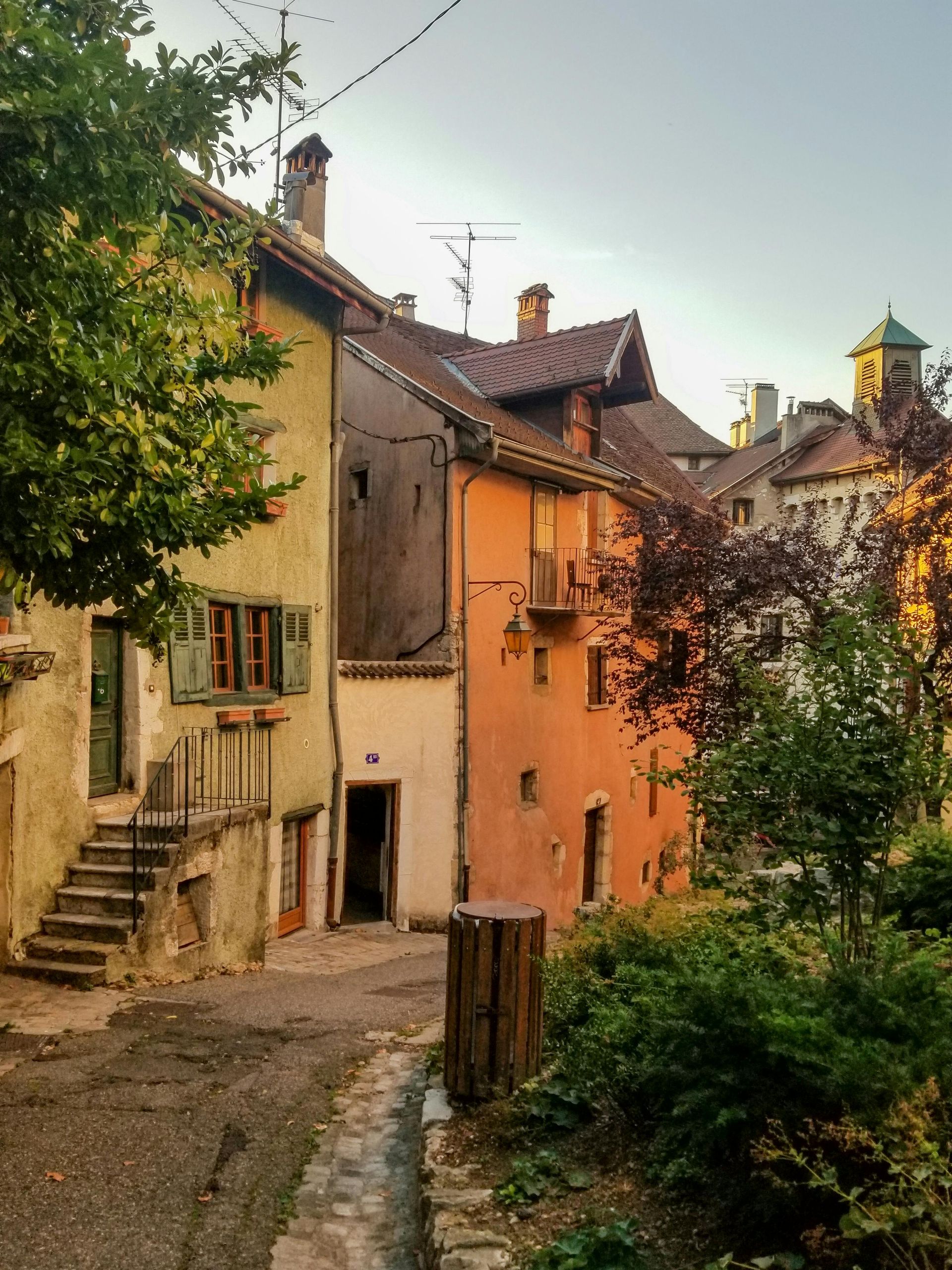 A row of buildings with a trash can in the middle in Annecy, France.