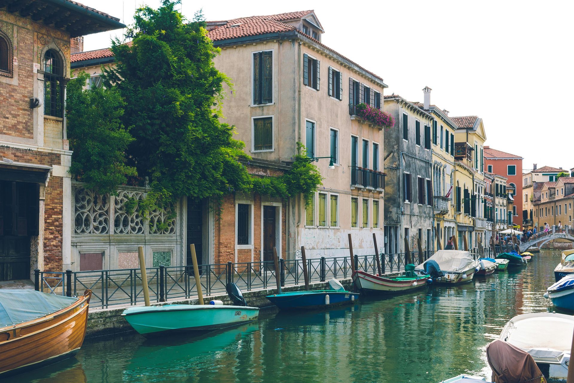 A row of buildings along a canal with boats in the water in Venice, Italy.