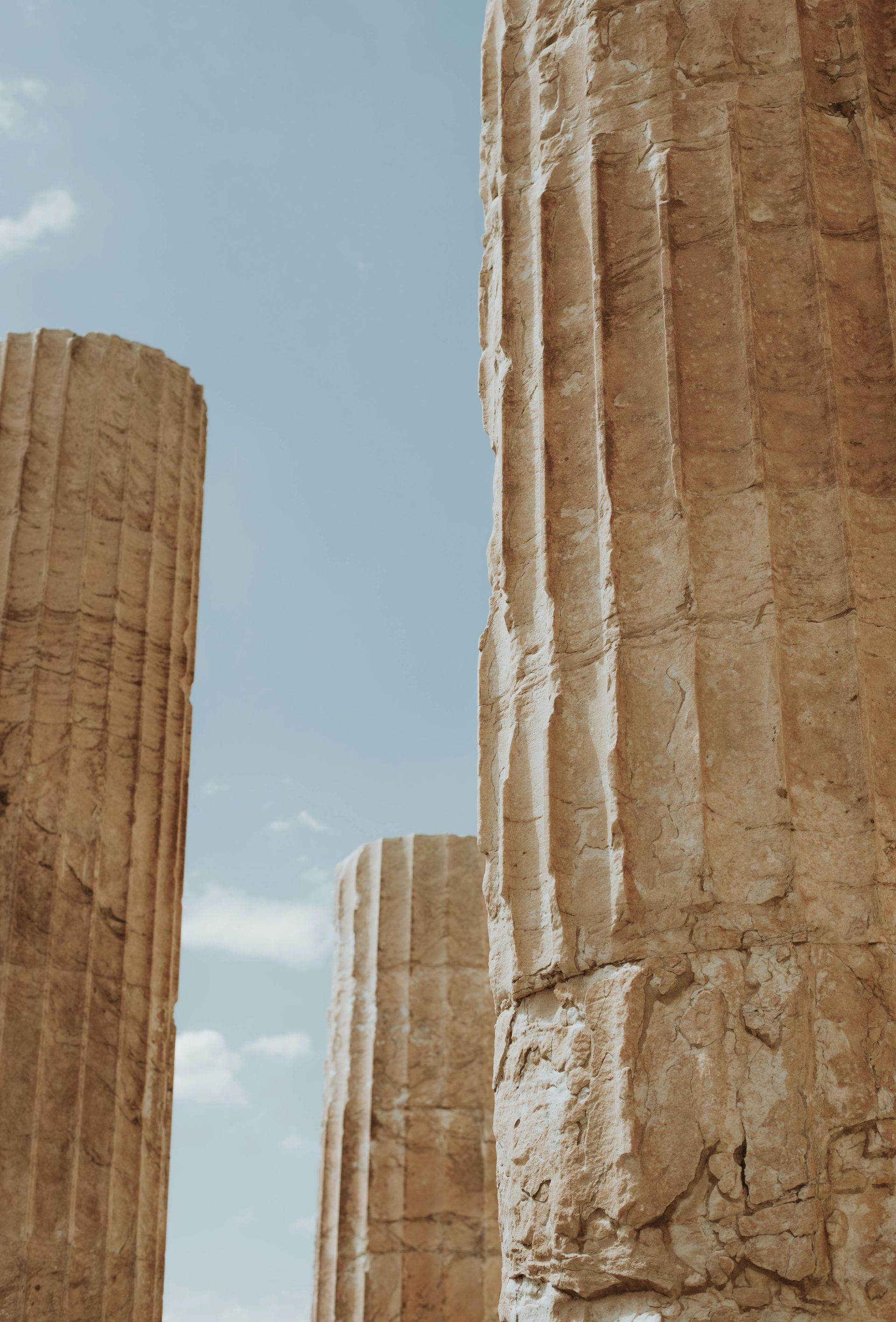 A row of stone columns against a blue sky in Athens, Greece.