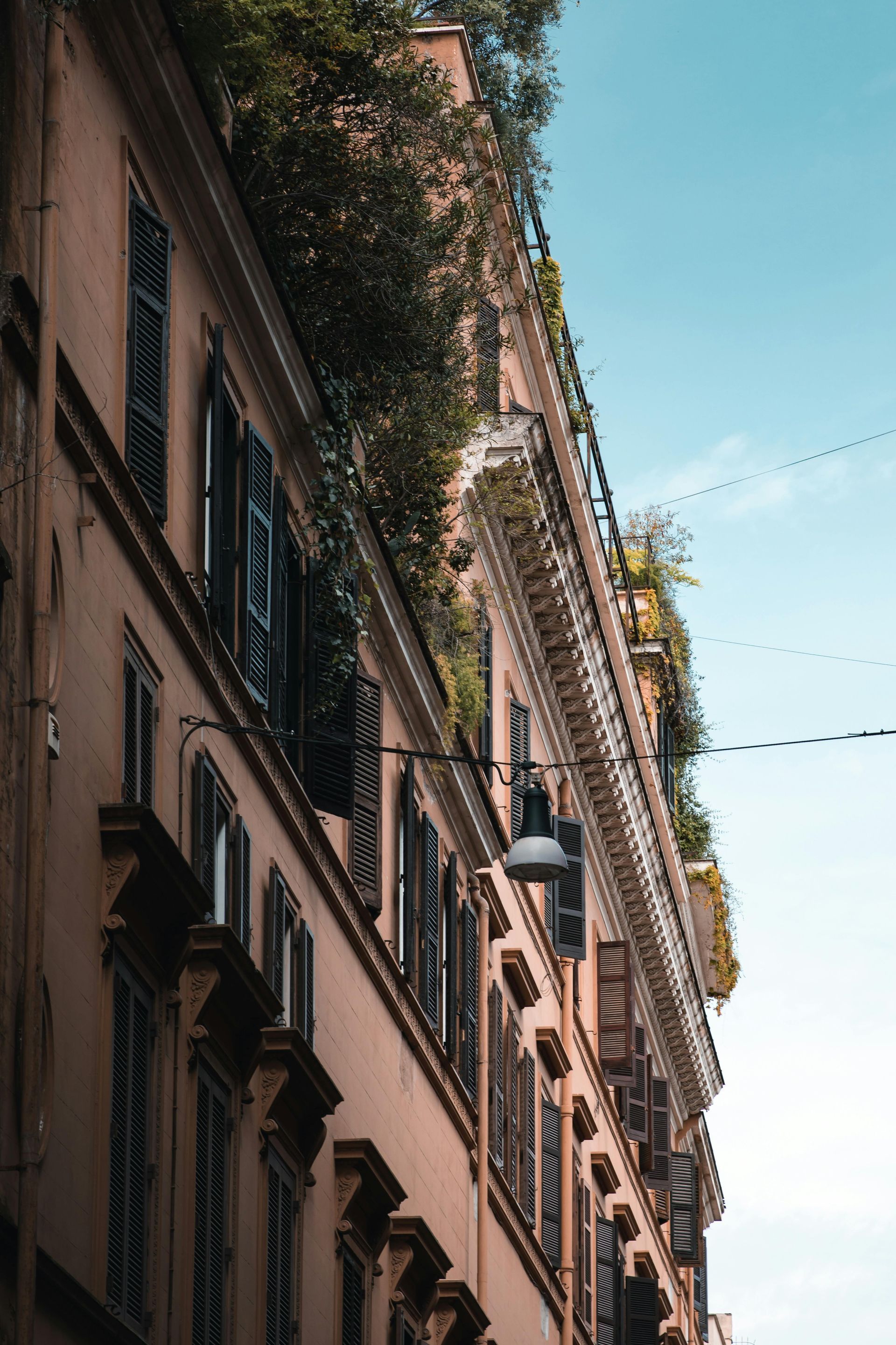 A tall building with a lot of windows and shutters on it in Florence, Italy.