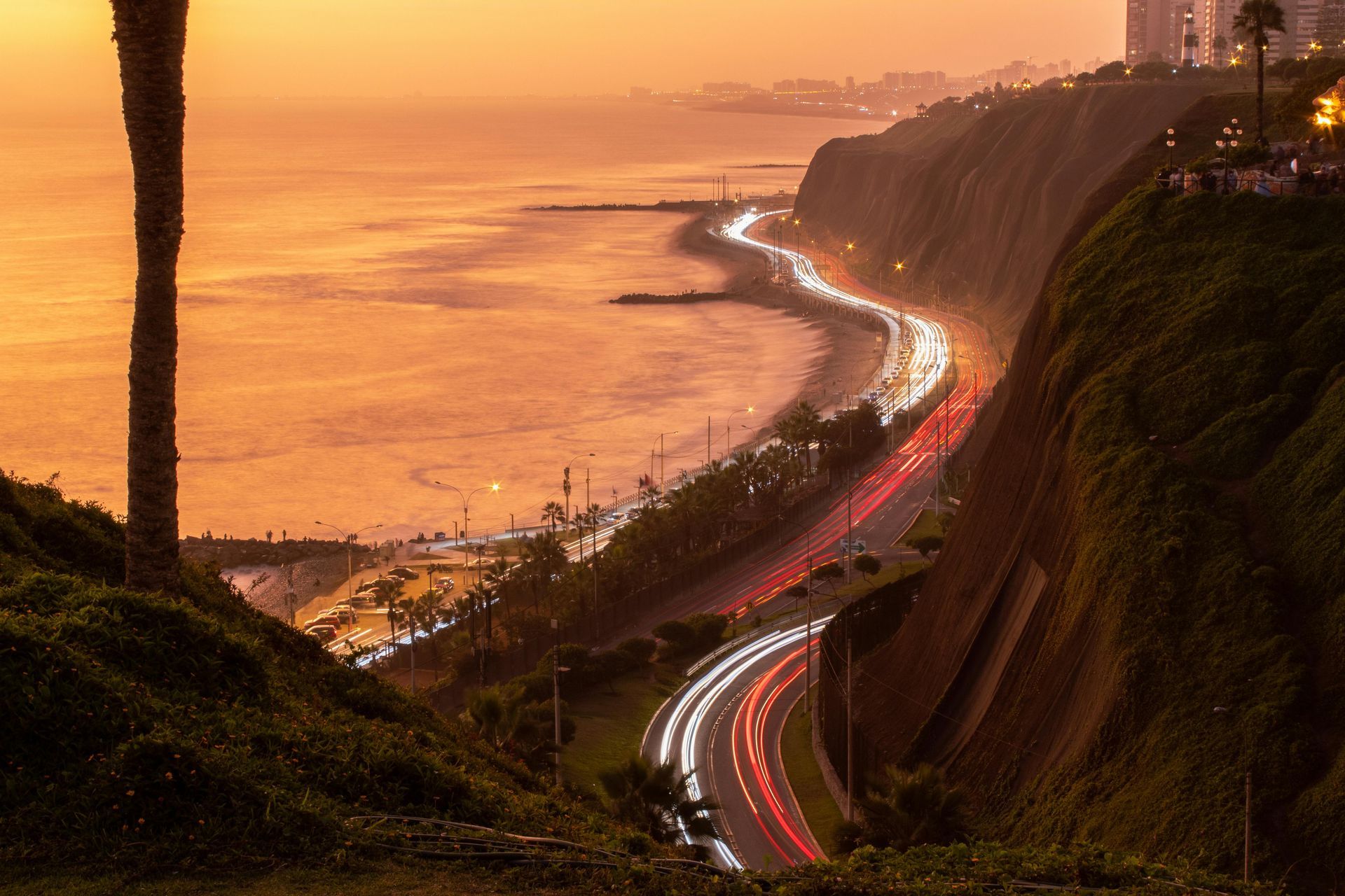 A road going down a hill next to the ocean at sunset in Cusco, Peru