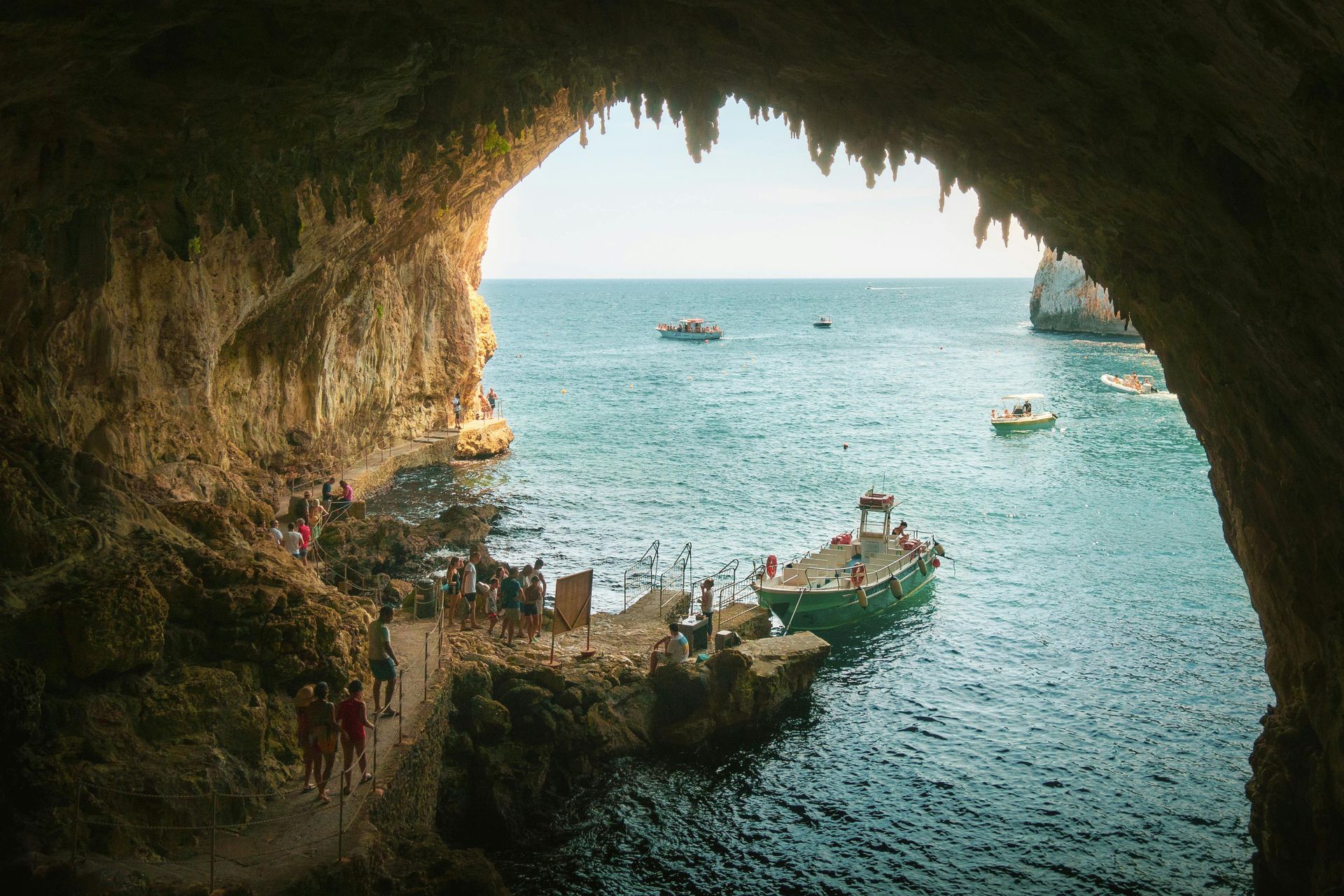 A boat is docked in a cave in the middle of the ocean in Puglia, Italy.