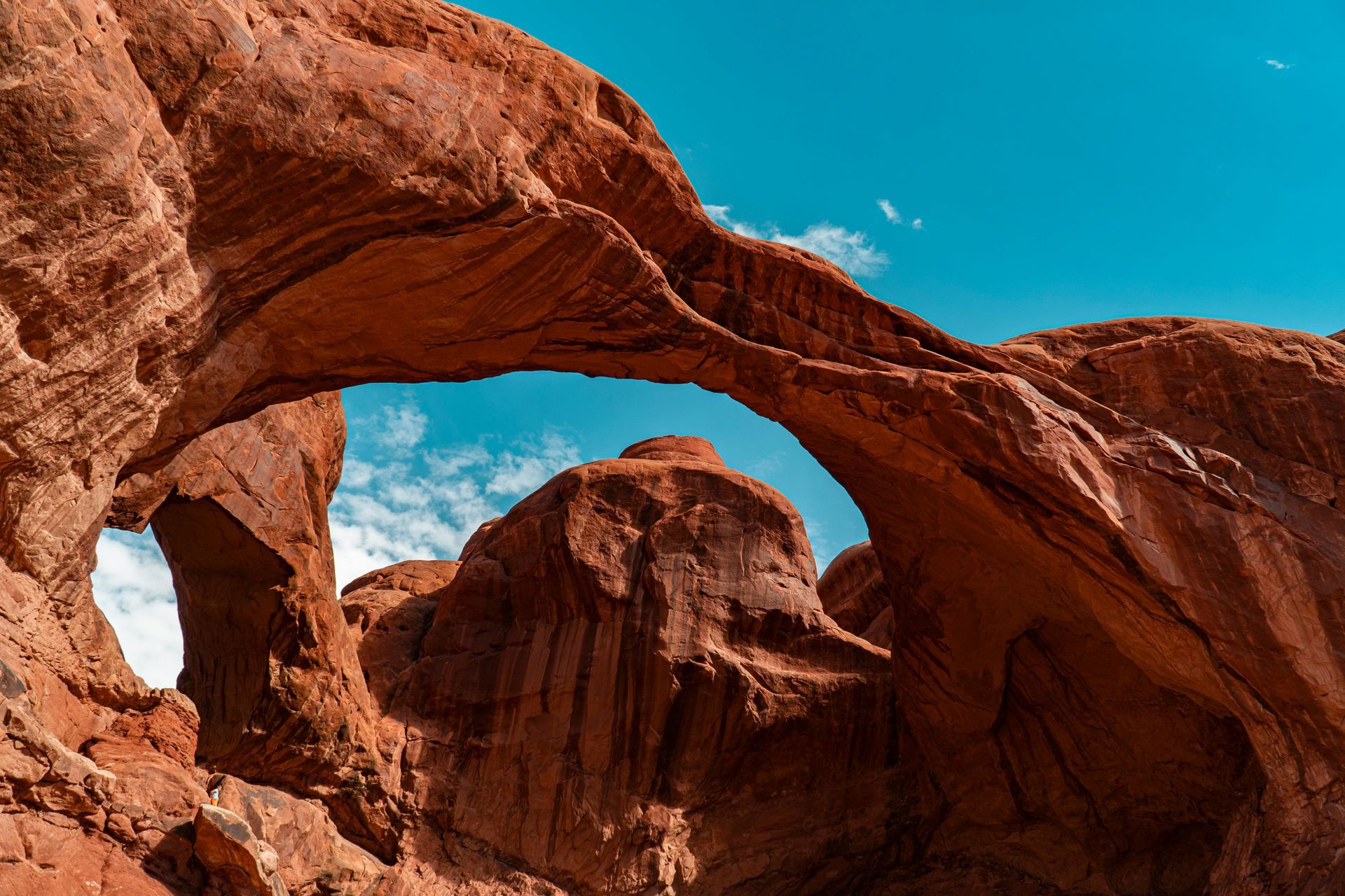 A large rock formation in the desert with a blue sky in the background at Arches National Park in Utah.