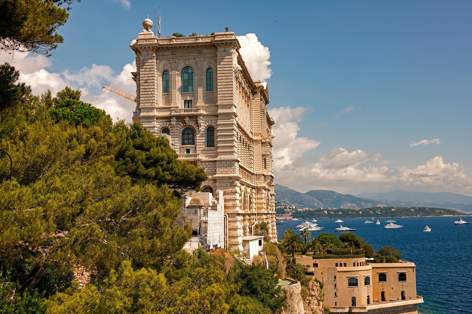 A large building sits on top of a cliff overlooking the ocean in Monaco.