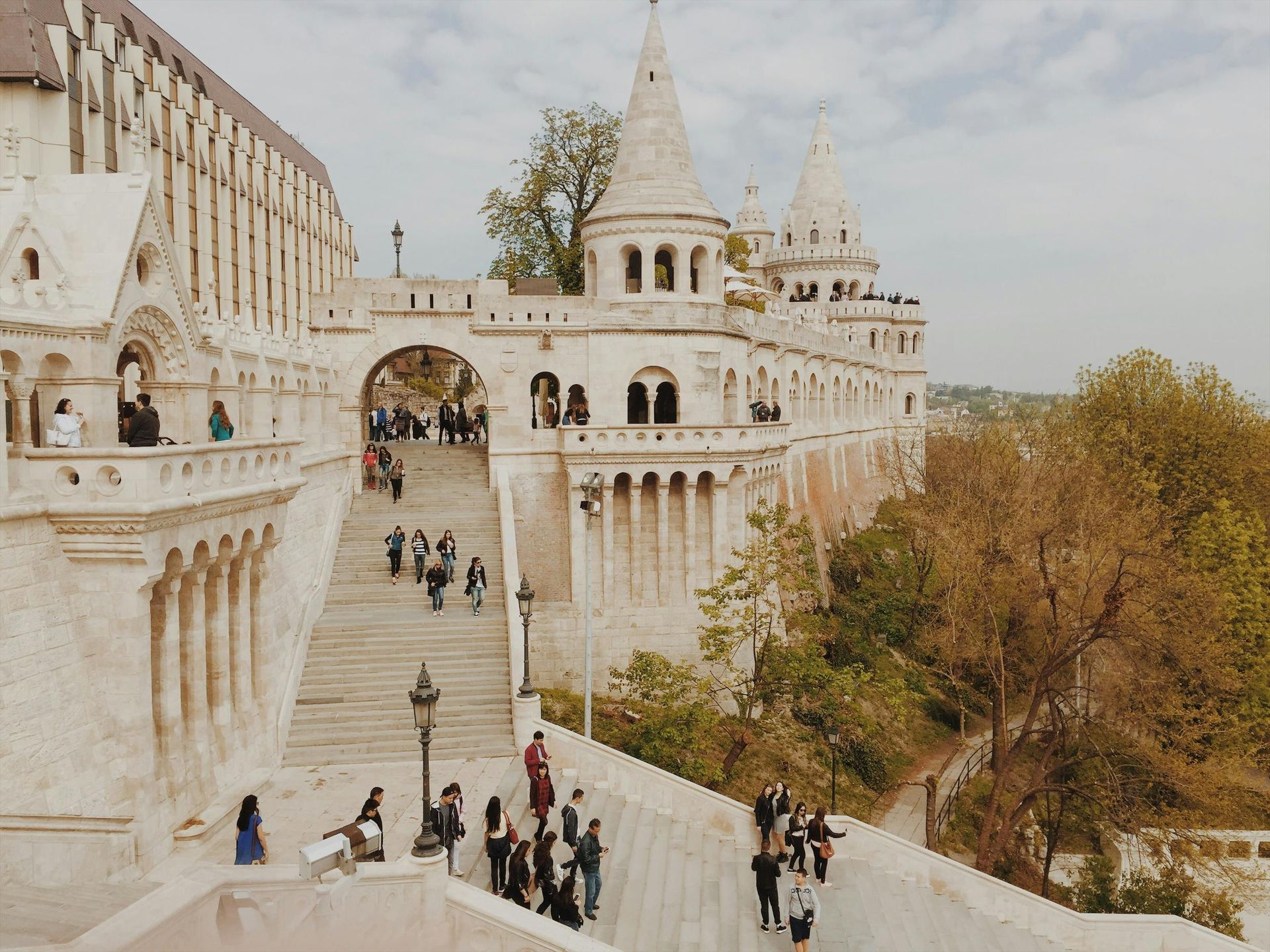 A group of people are walking up stairs to Fisherman's Bastion in Budapest, Hungary.