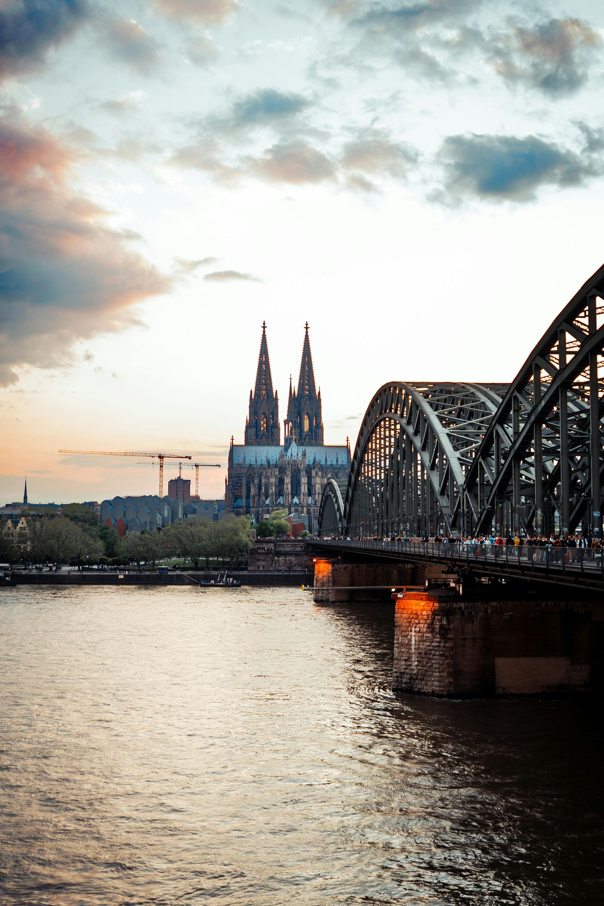 A bridge over The Rhine River with a cathedral in the background.