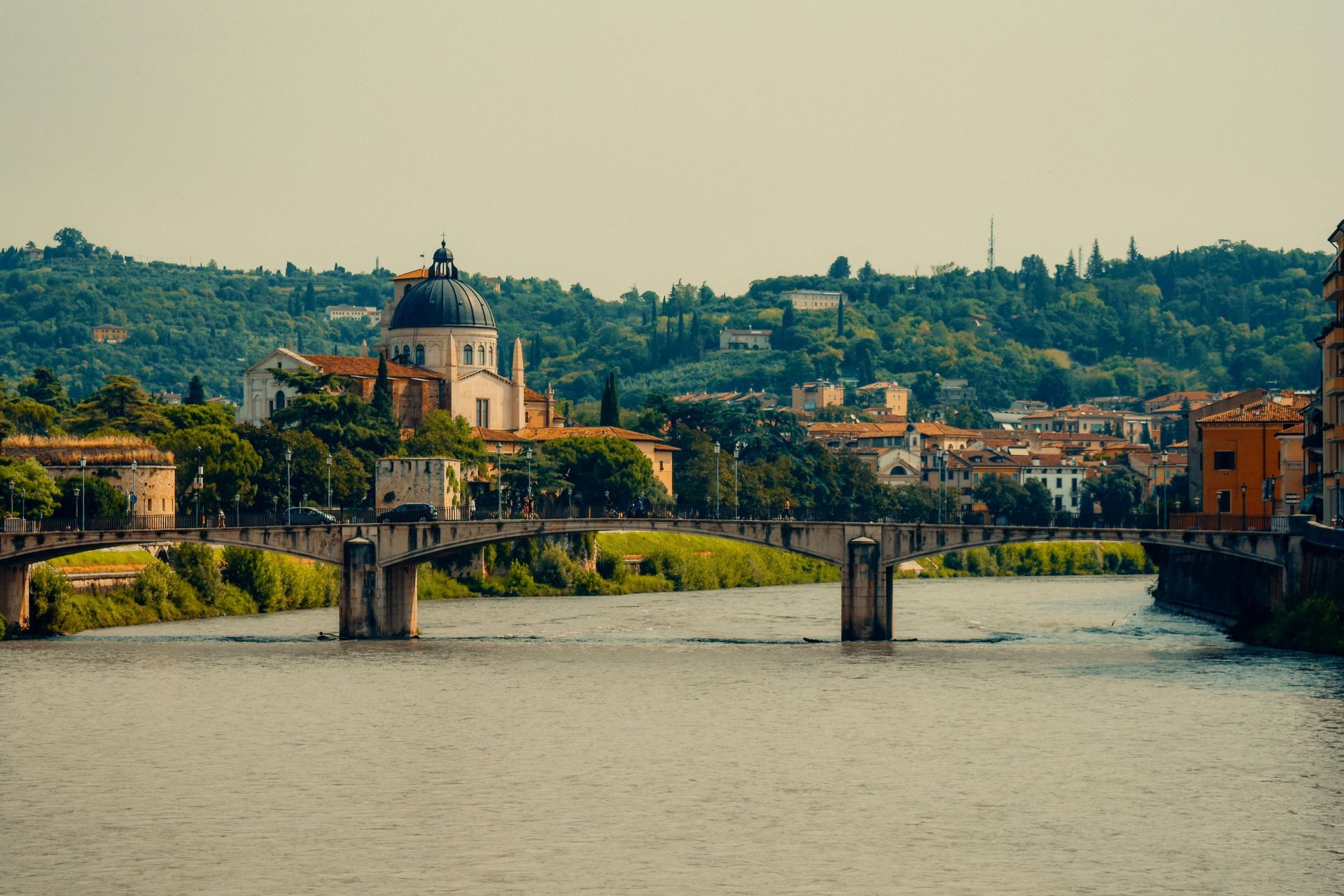 A bridge over a river with Verona, Italy  the background