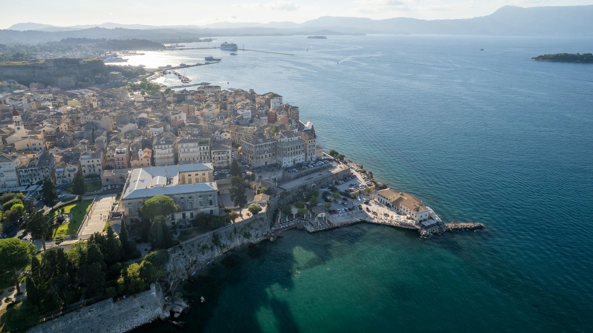 An aerial view of a city surrounded by water and mountains in Corfu, Greece.