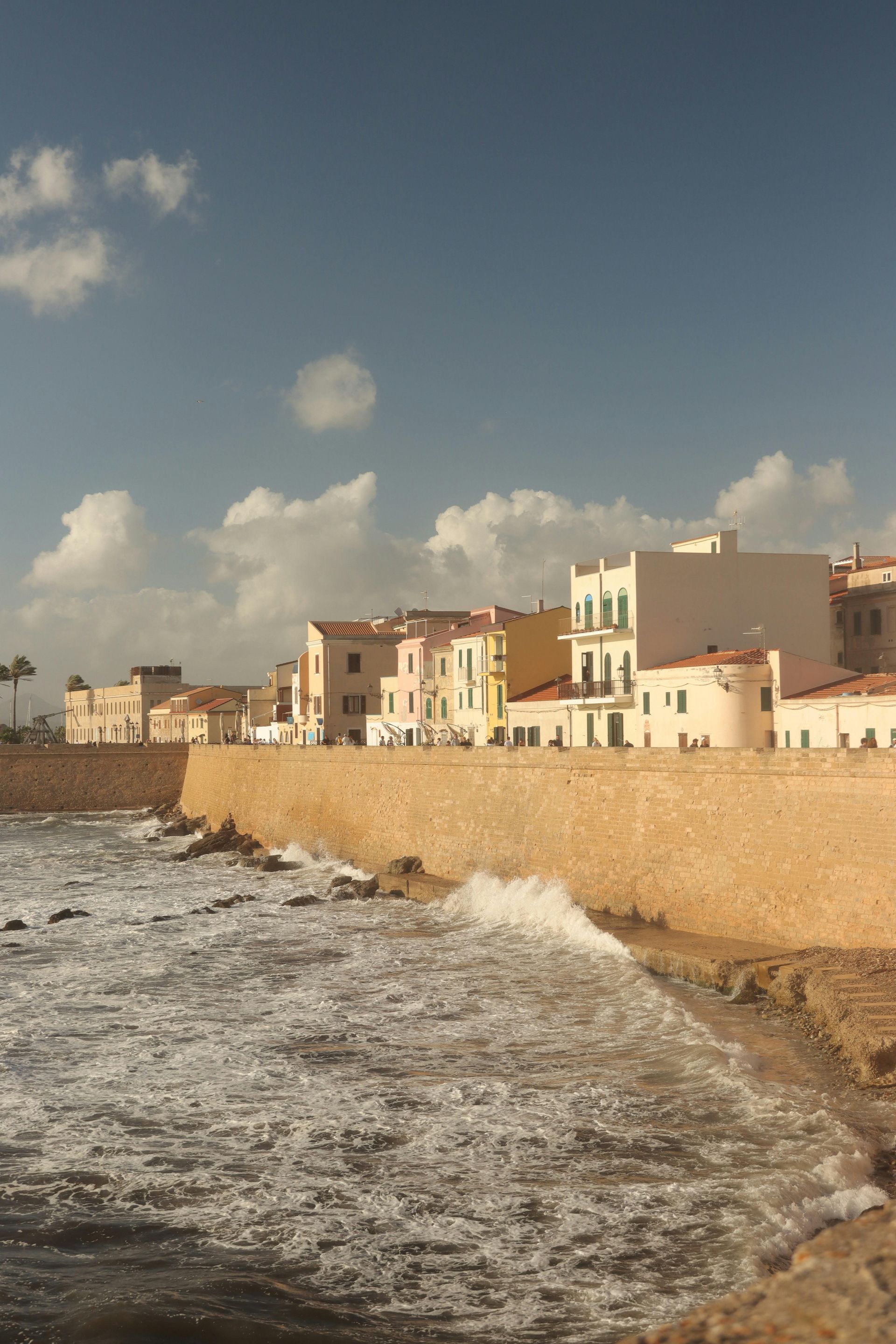 A row of buildings along the shore of a body of water in Sardinia, Italy.