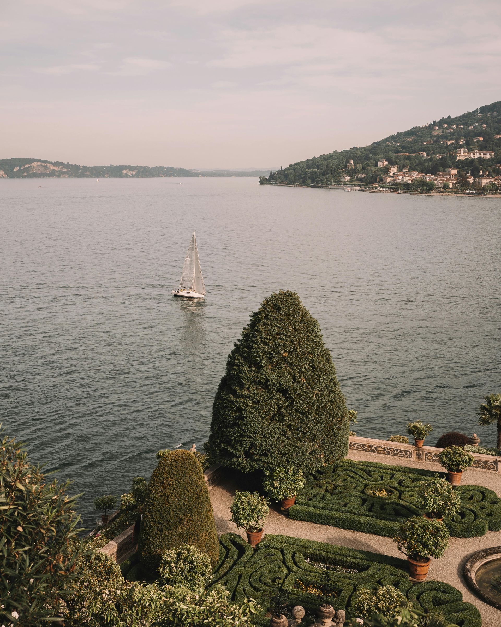 An aerial view of Lake Como with a sailboat in the water in Italy.