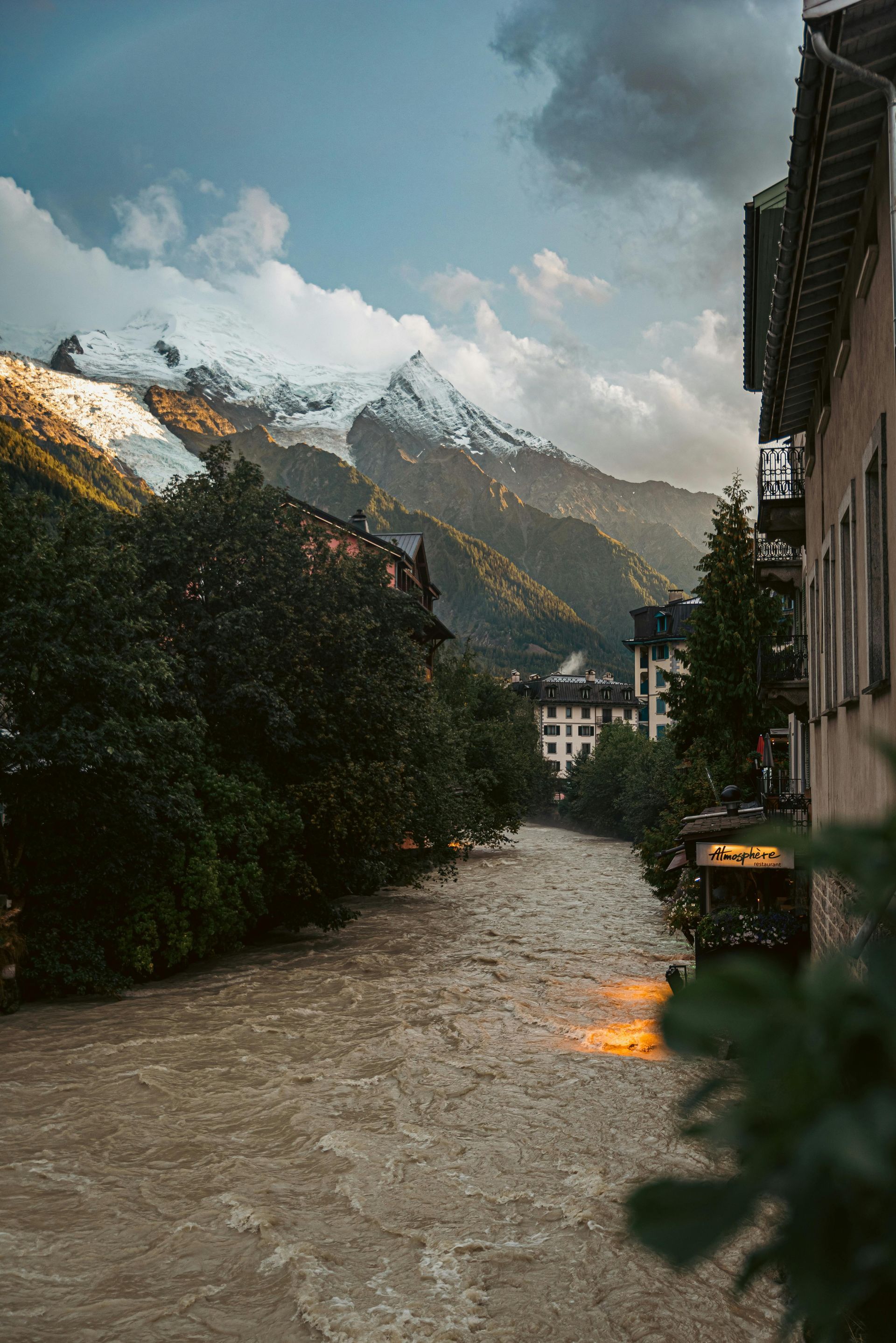 A river running through a city with mountains in the background in Chamonix, France.