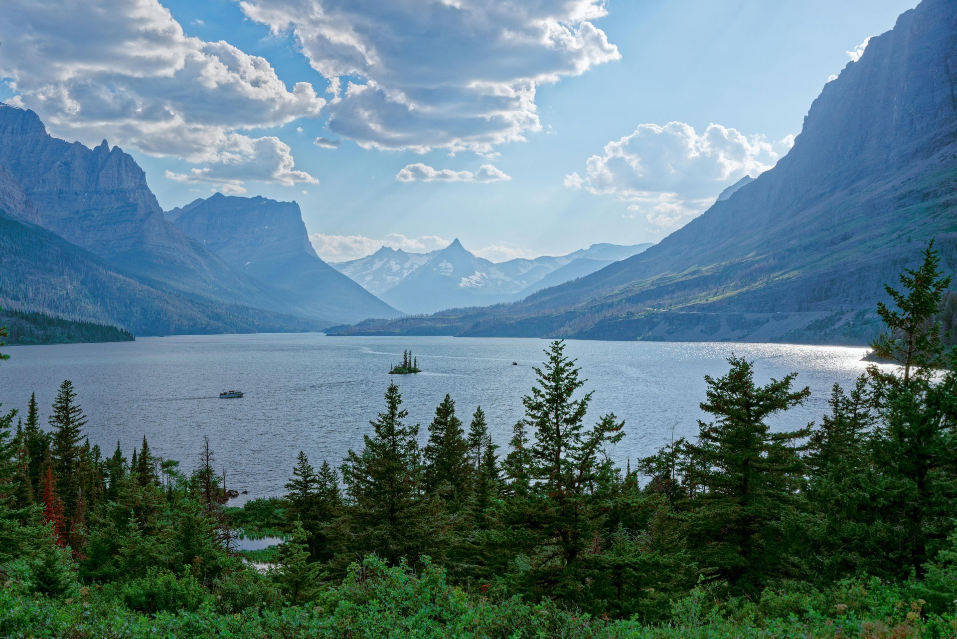 Saint Mary Lake surrounded by mountains and trees with mountains in the background at Glacier National Park in Montana. 