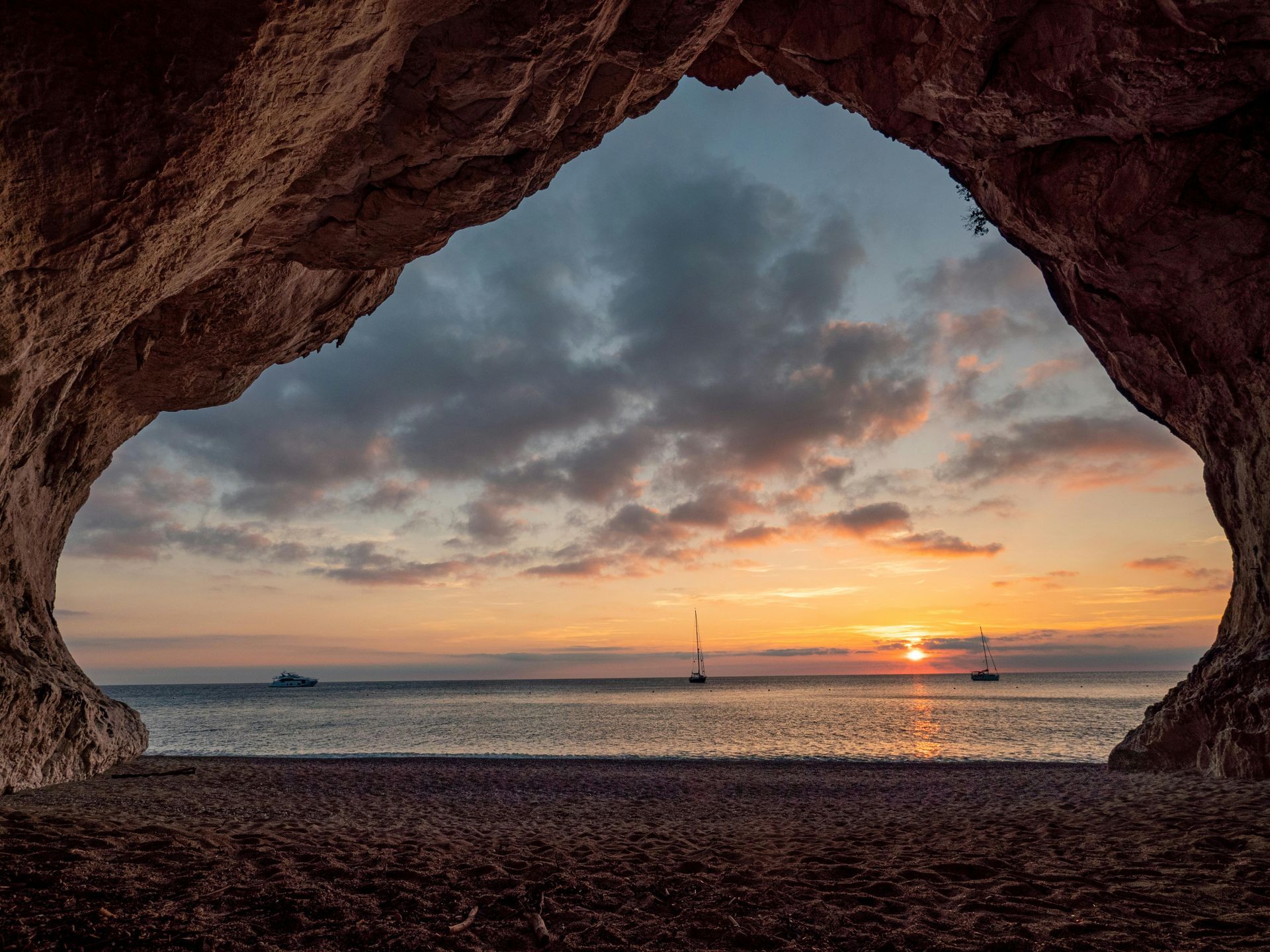 A view of a sunset over the ocean from inside a cave in Sardinia, Italy.