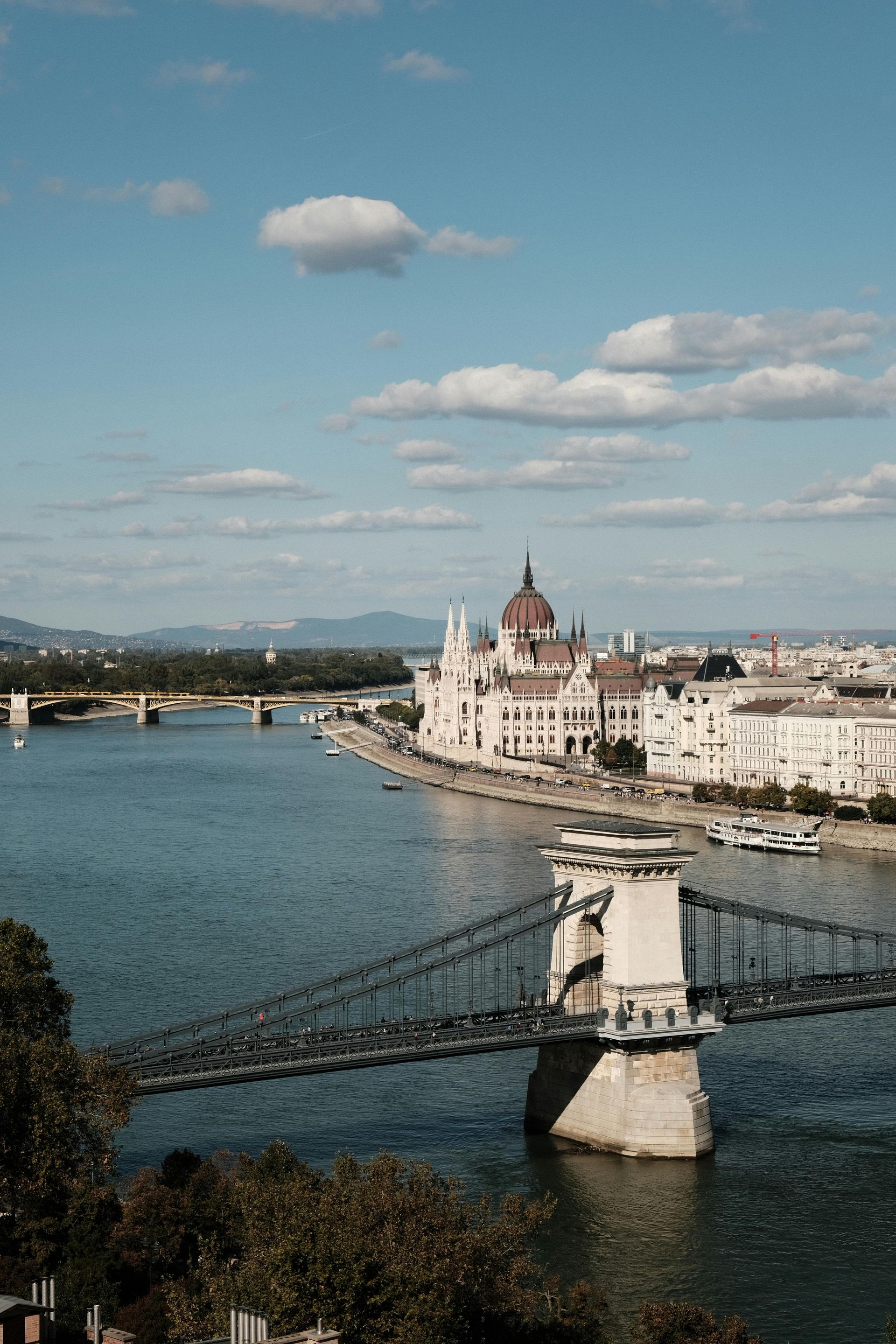 A bridge over The Danube River with a city in the background.