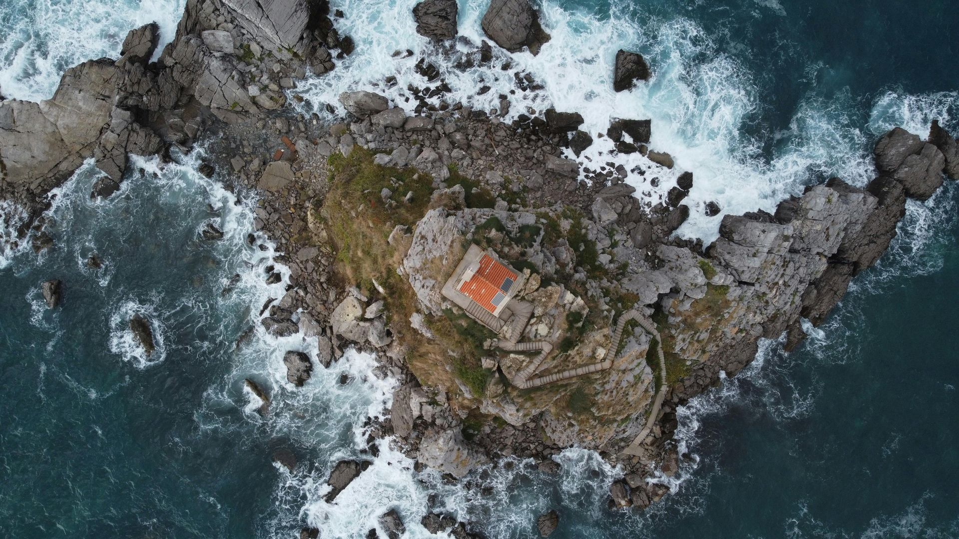 An aerial view of a small rocky island in the middle of the ocean in the Balkans. 