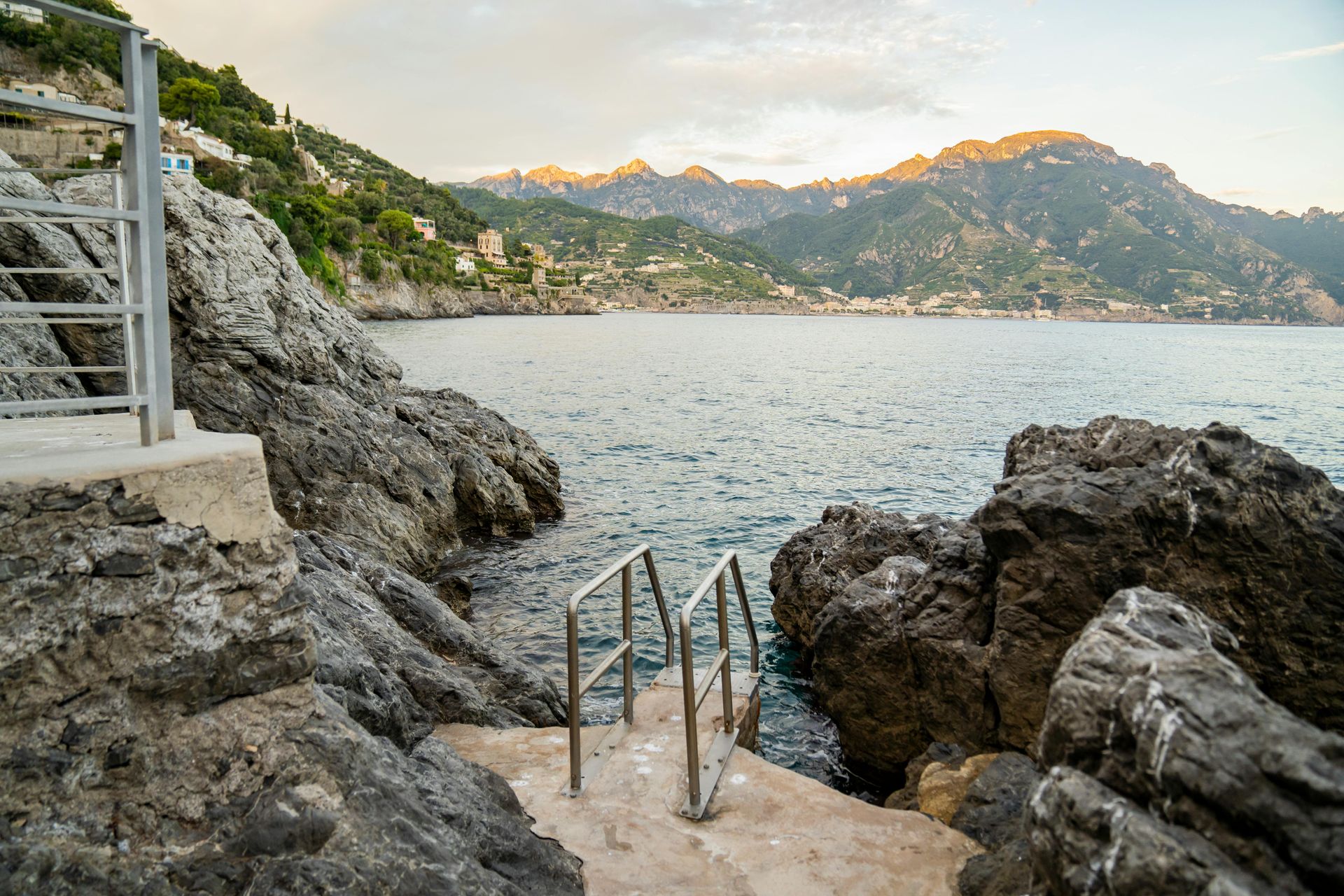 A staircase leading to the ocean on a rocky shore in the Amalfi Coast, Italy.