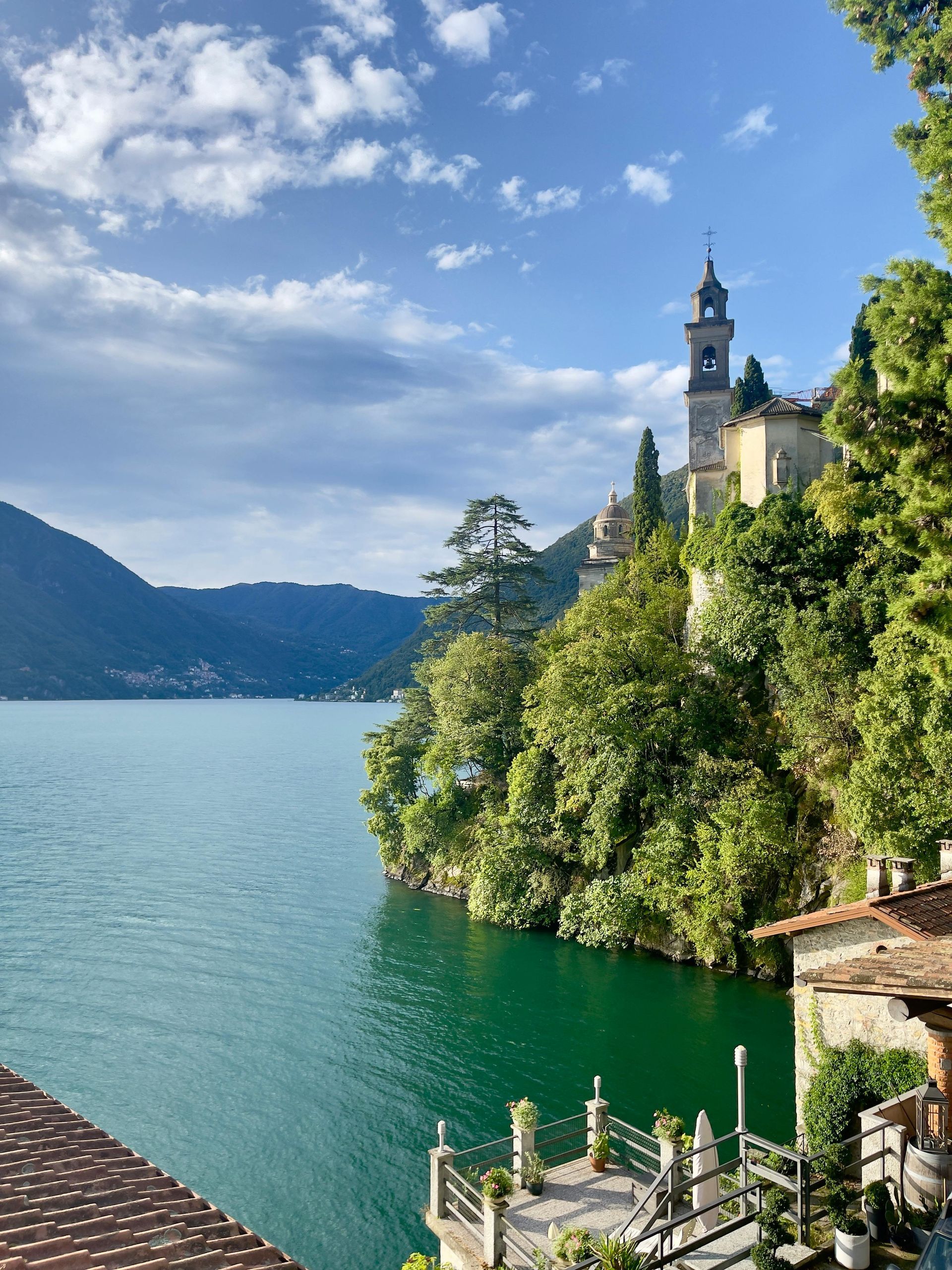 Lake Como is surrounded by trees and mountains in Italy.