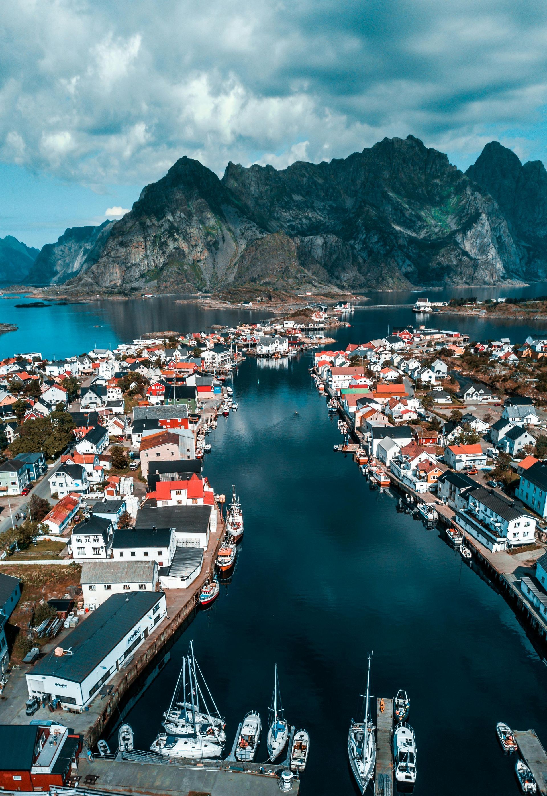 An aerial view of a small town surrounded by water and mountains in Norway.