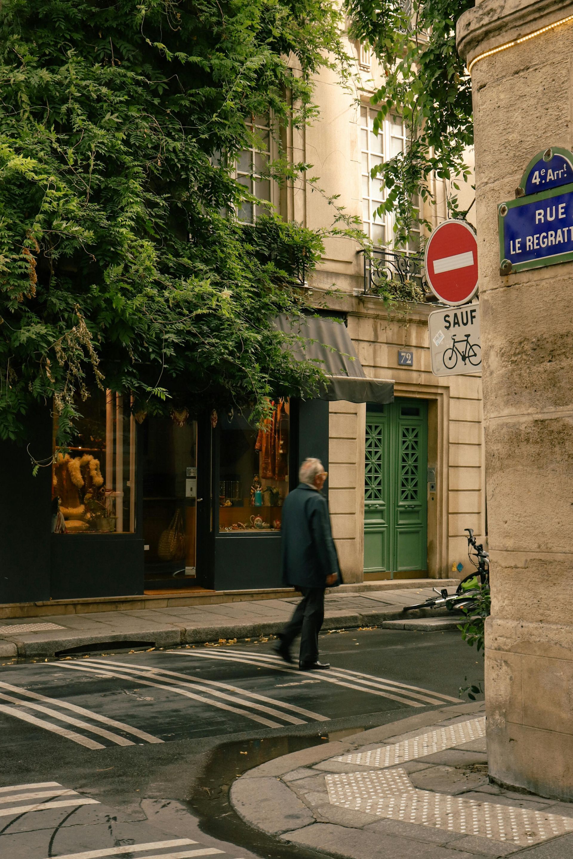 A man is walking across a street in front of a building in Côte d’Azur.