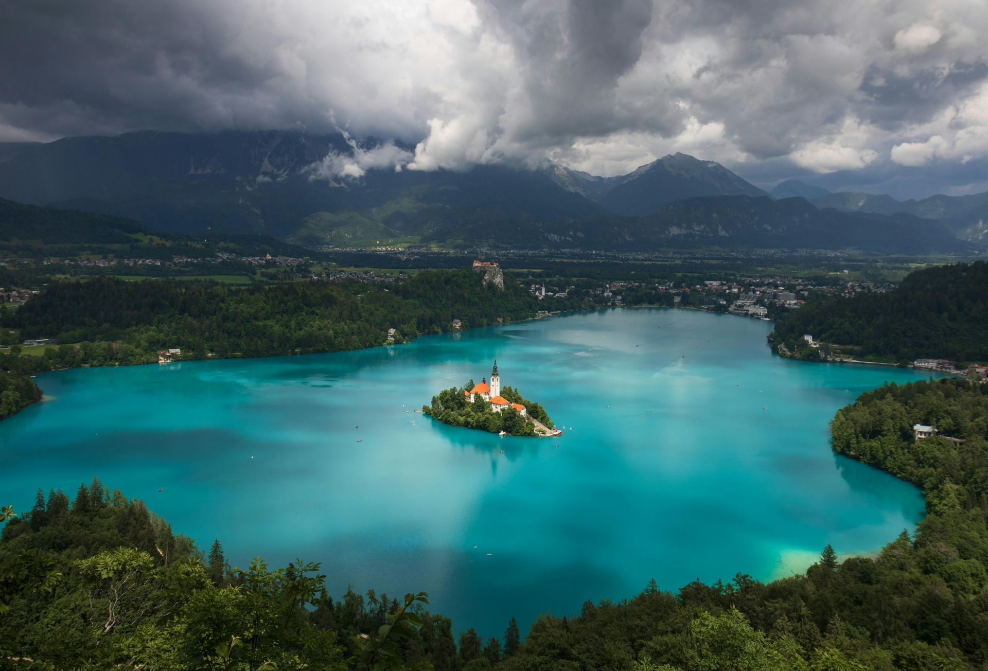 A small island in the middle of Lake Bled with mountains in the background in Slovenia. 