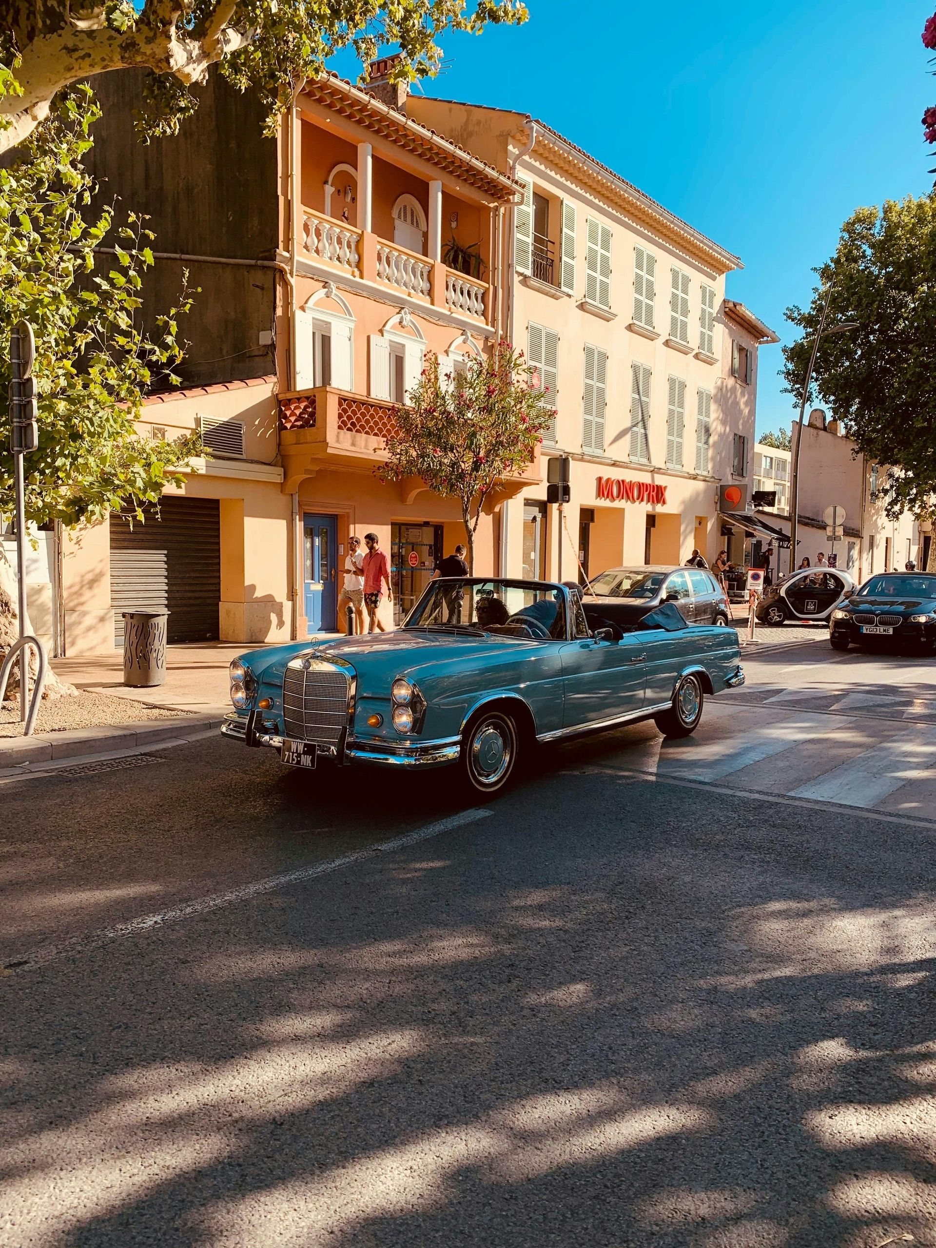 A blue car is parked on the side of the road in front of a building in Côte d’Azur.