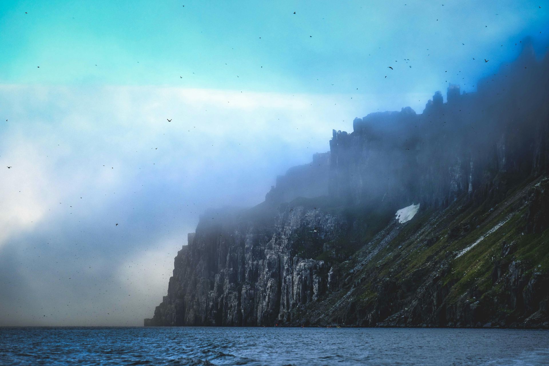 There is a mountain in the background and a body of water in the foreground.