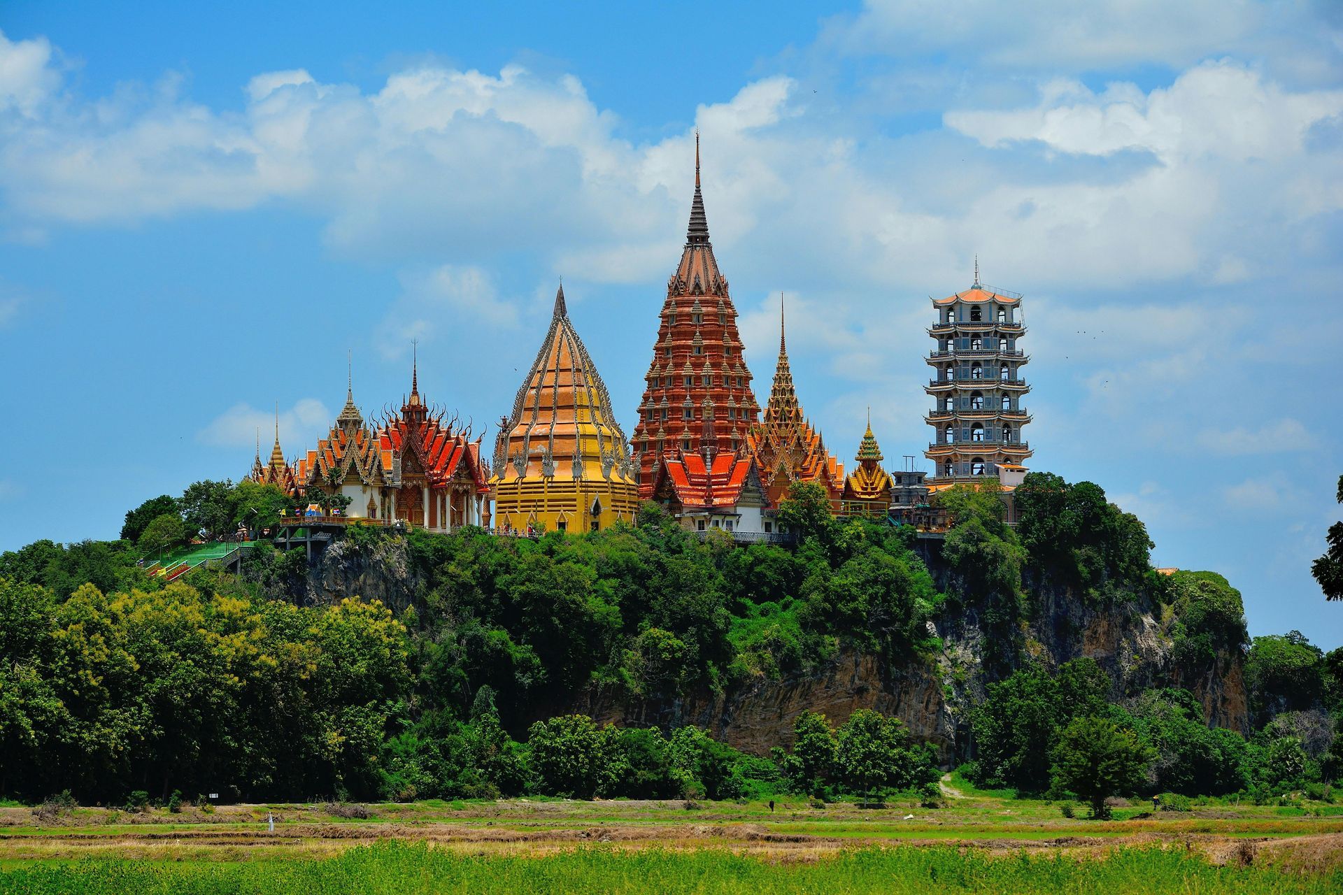 A group of temples are sitting on top of a hill in Thailand.