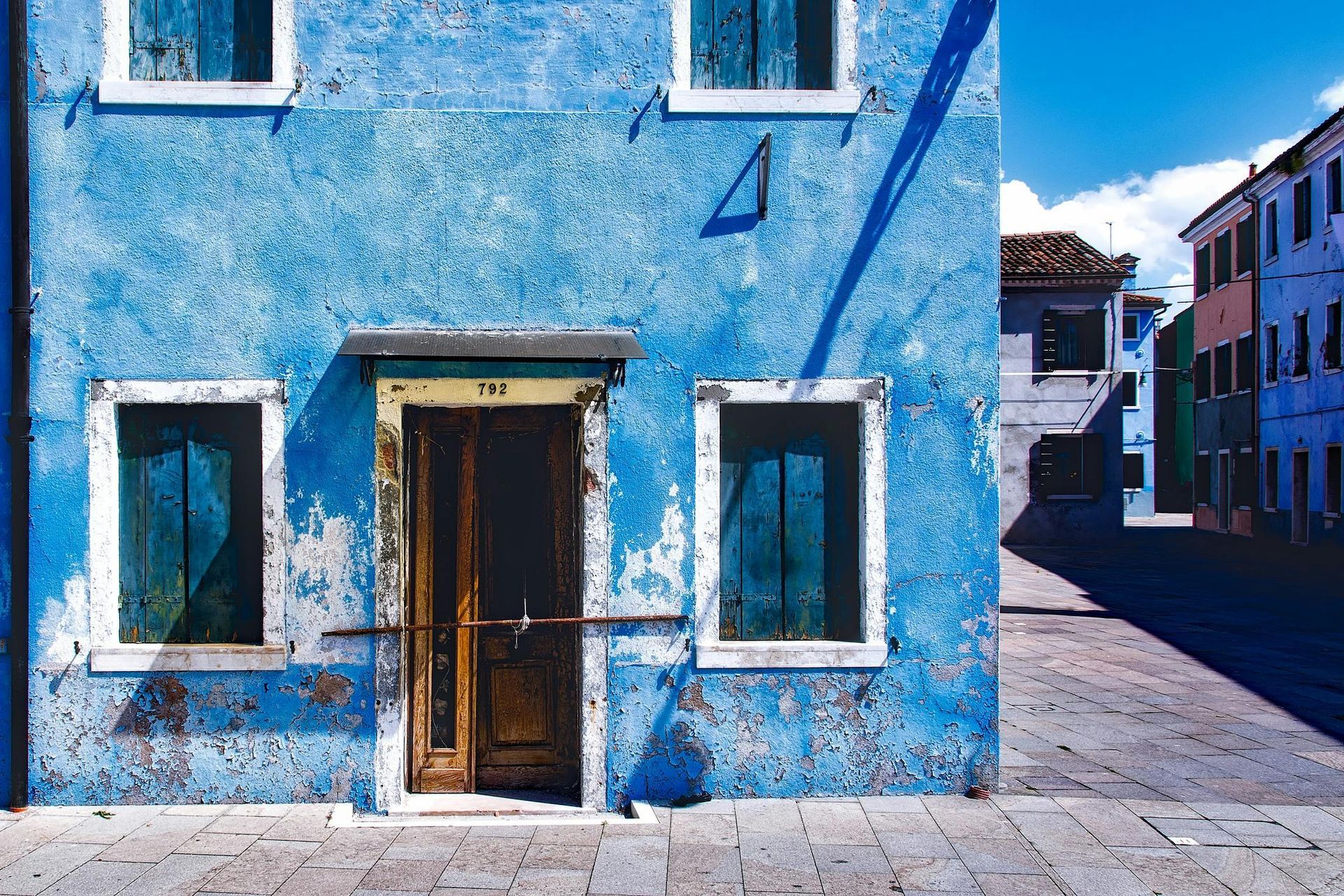 A blue building with a wooden door and windows