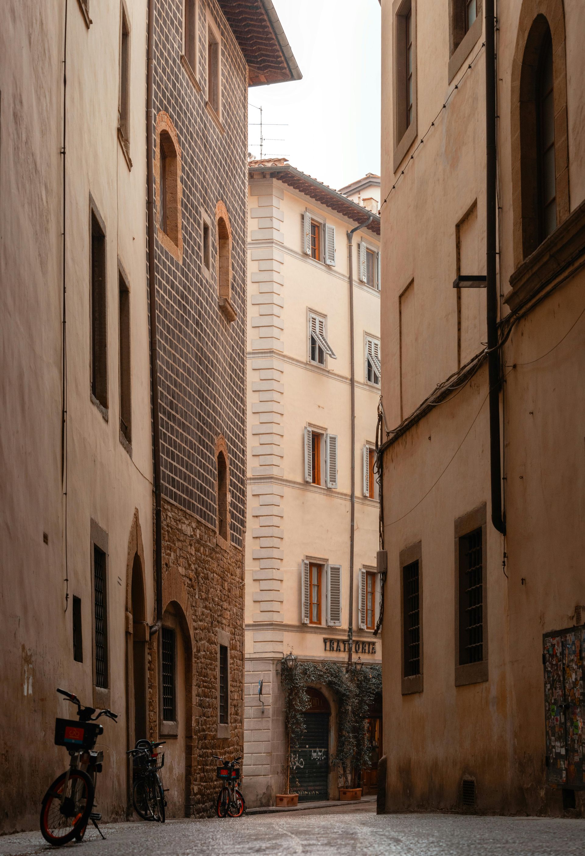 A narrow alleyway with a bicycle parked in the middle in Florence, Italy.