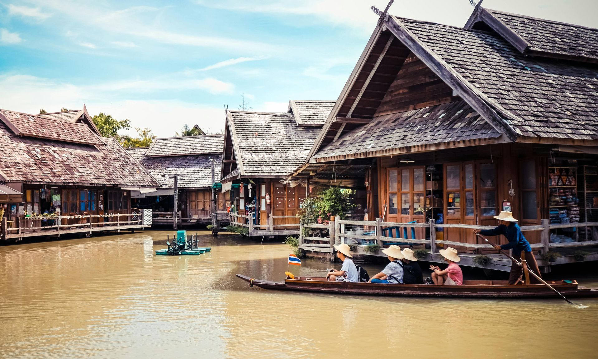 A group of people are riding a boat on a river in Thailand.