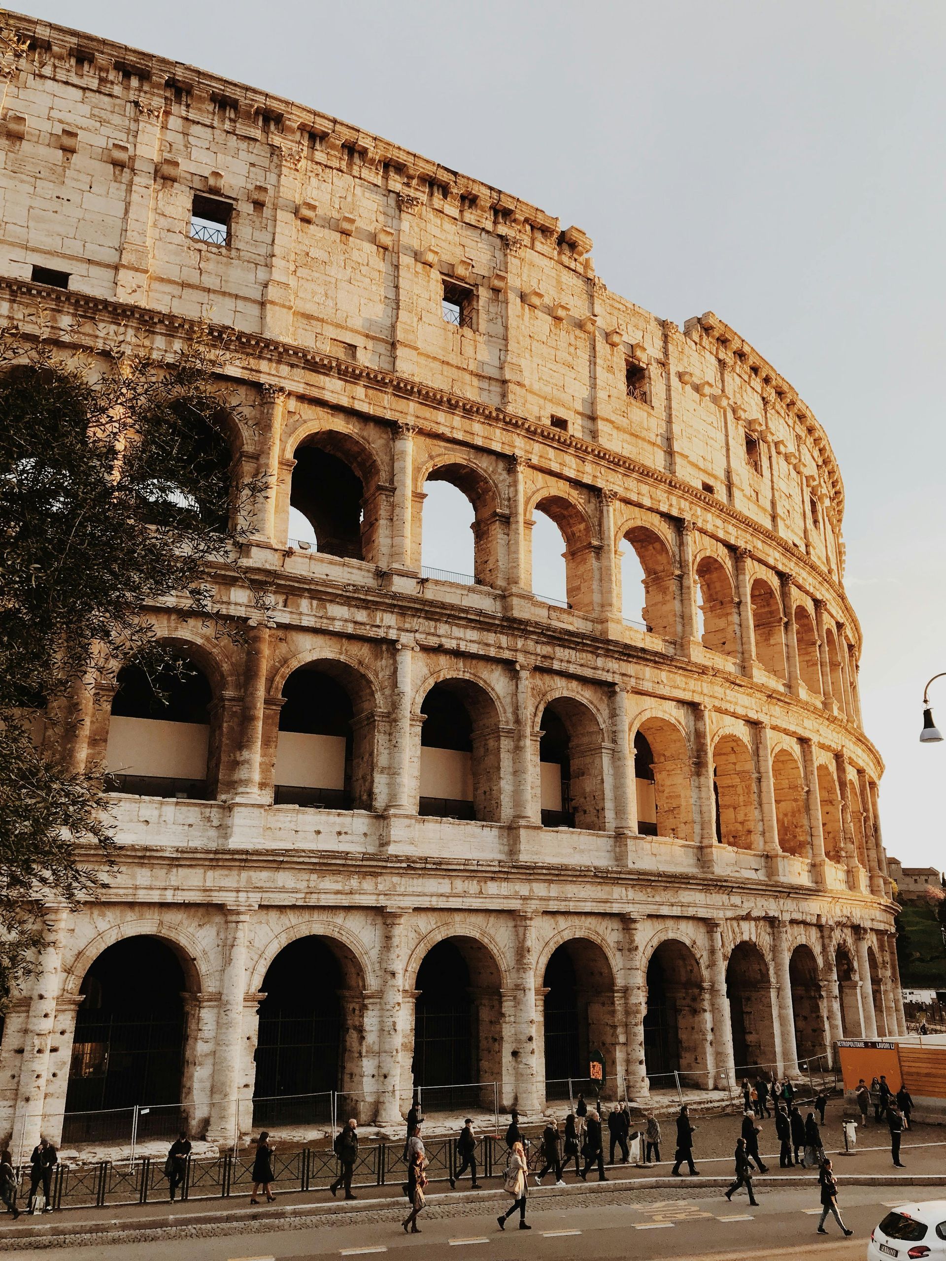 People are walking in front of the colosseum  in Rome, Italy.