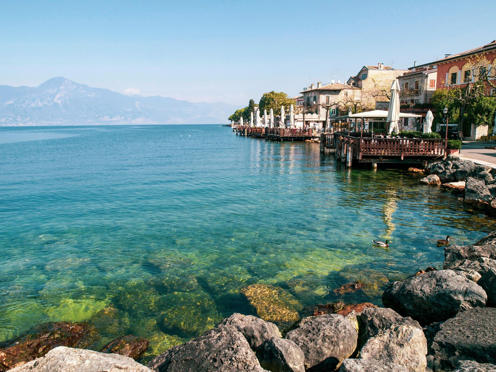 the mediterranean ocean surrounded by rocks and buildings.