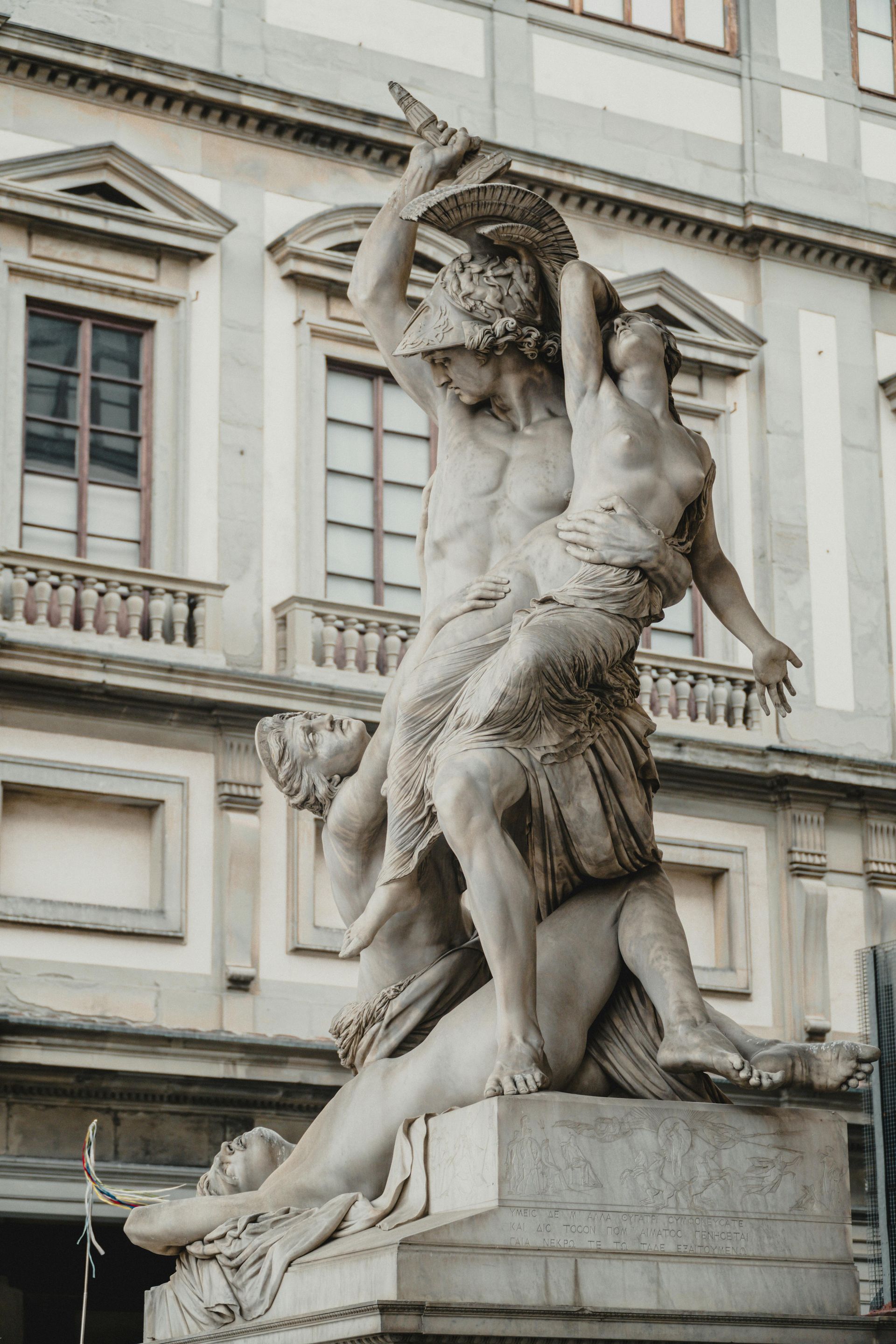 A statue of a man and a woman standing in front of a building in Florence, Italy.