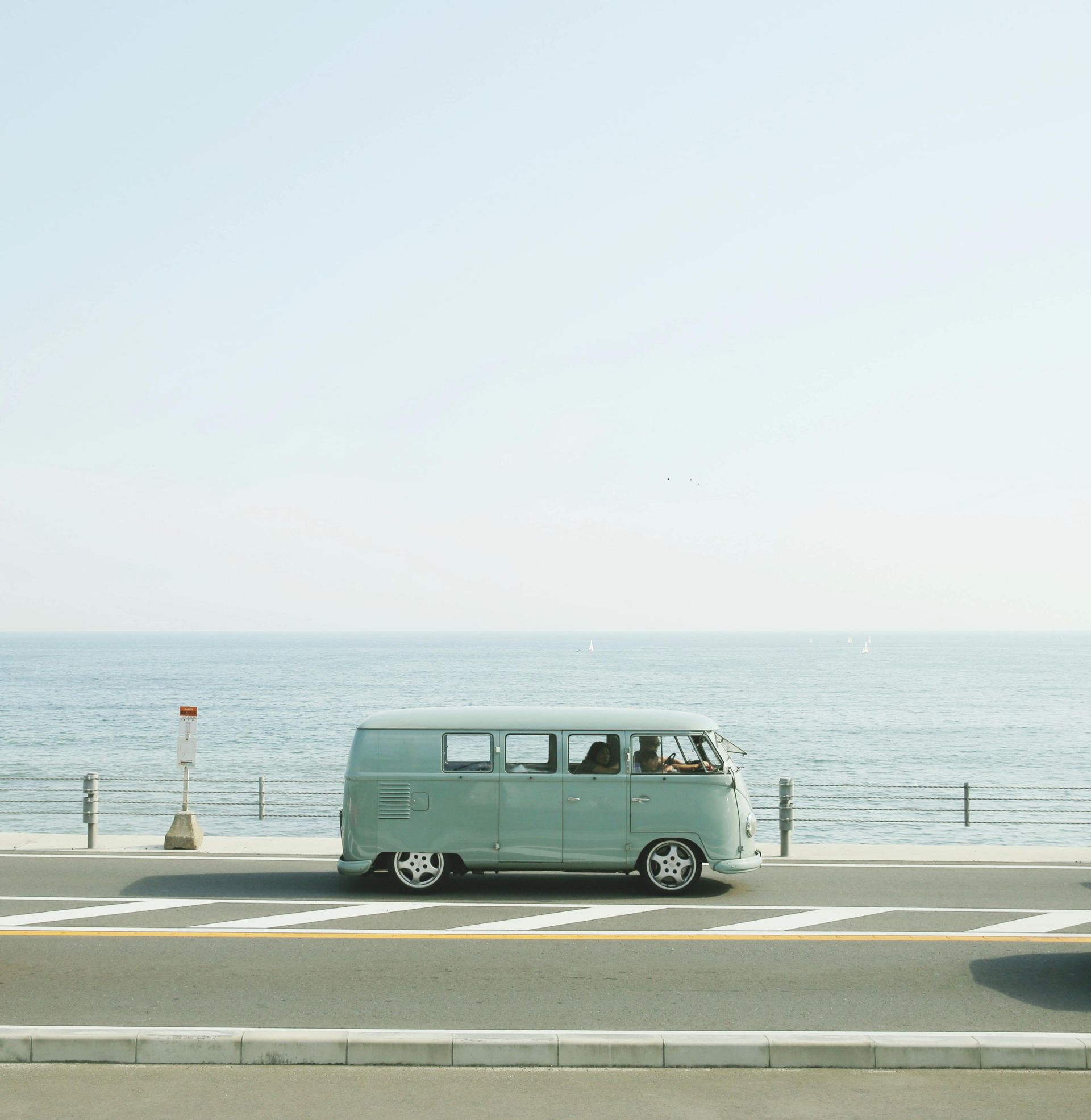 A van is parked on the side of the road near the ocean