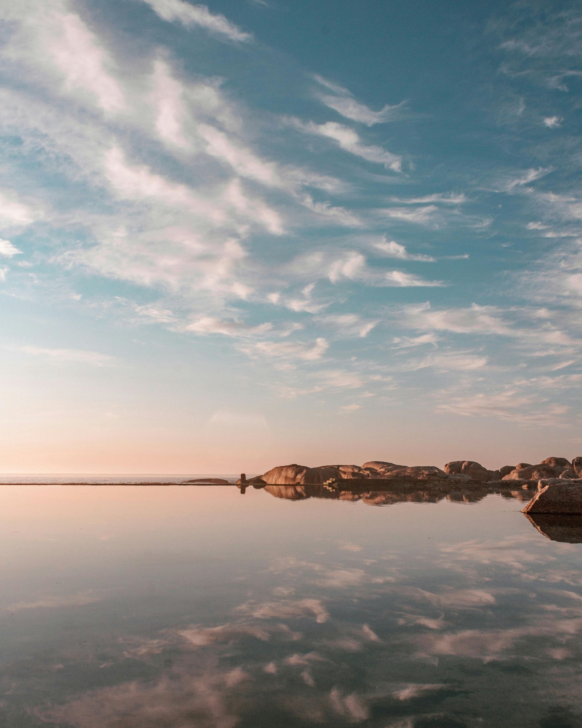 A body of water with a blue sky and clouds reflected in it in South Africa.