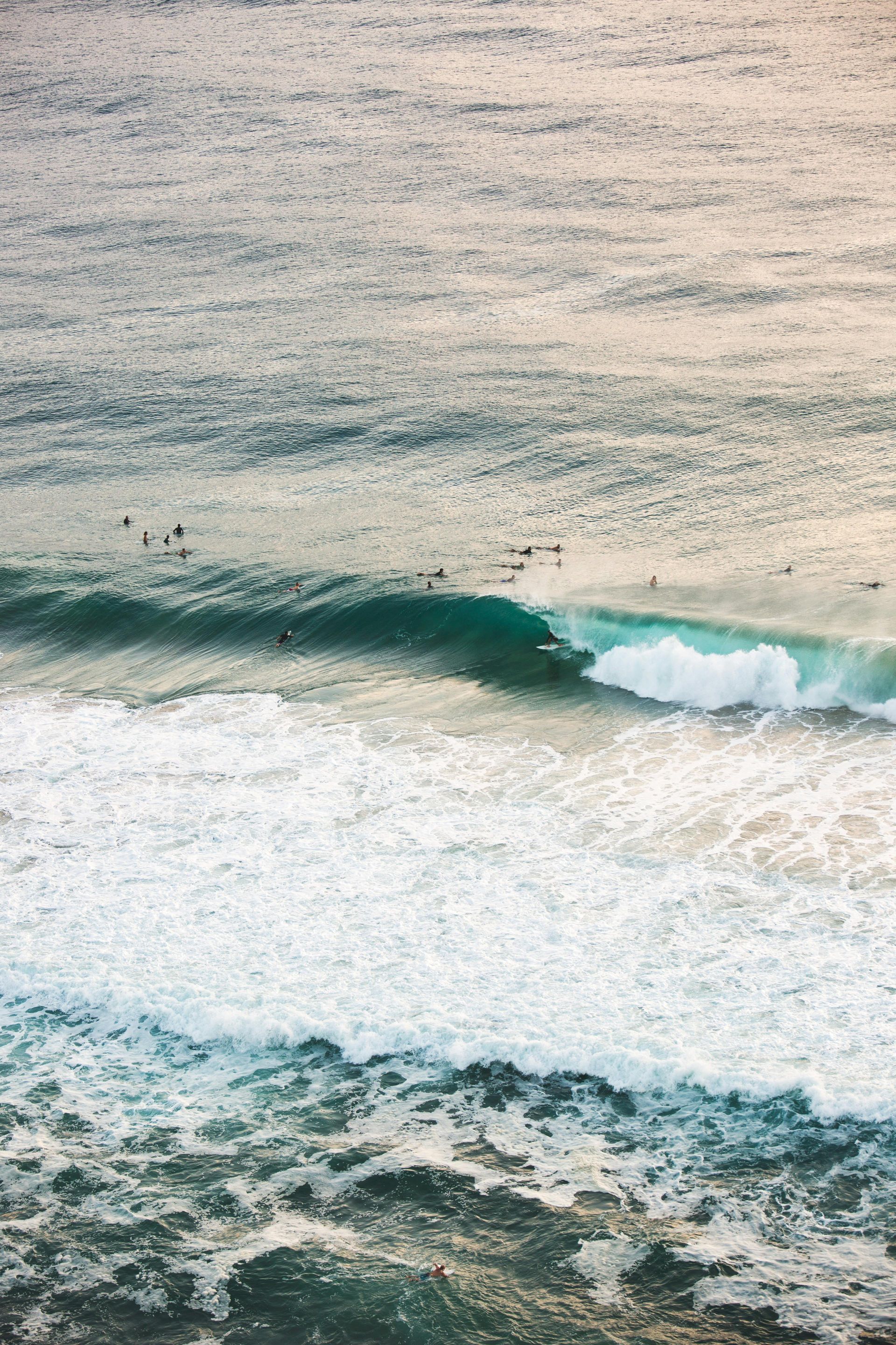 A wave is breaking on a rocky shoreline in the ocean in Australia.