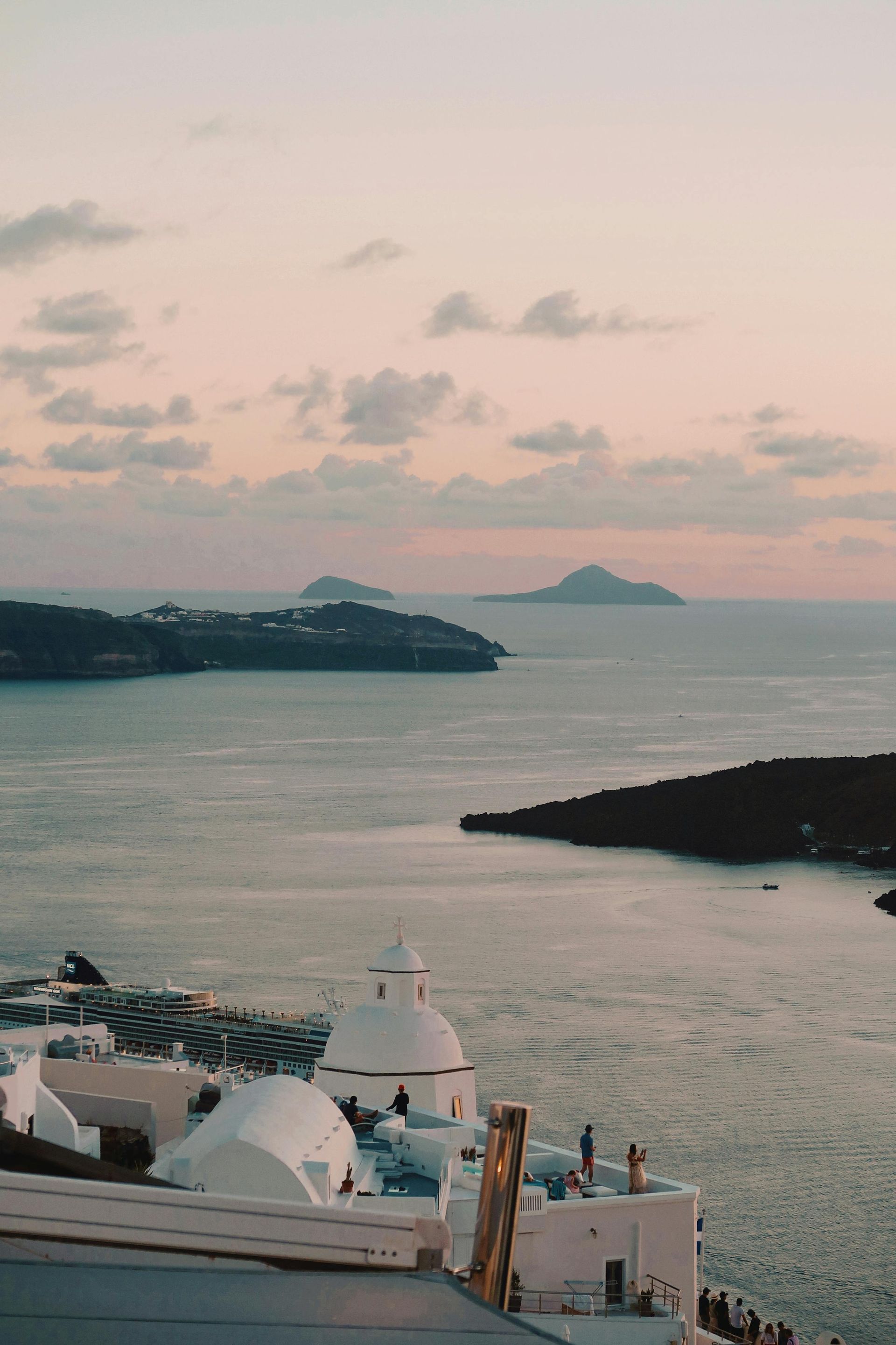 A view of a body of water with a sunset in the background in Santorini, Greece.