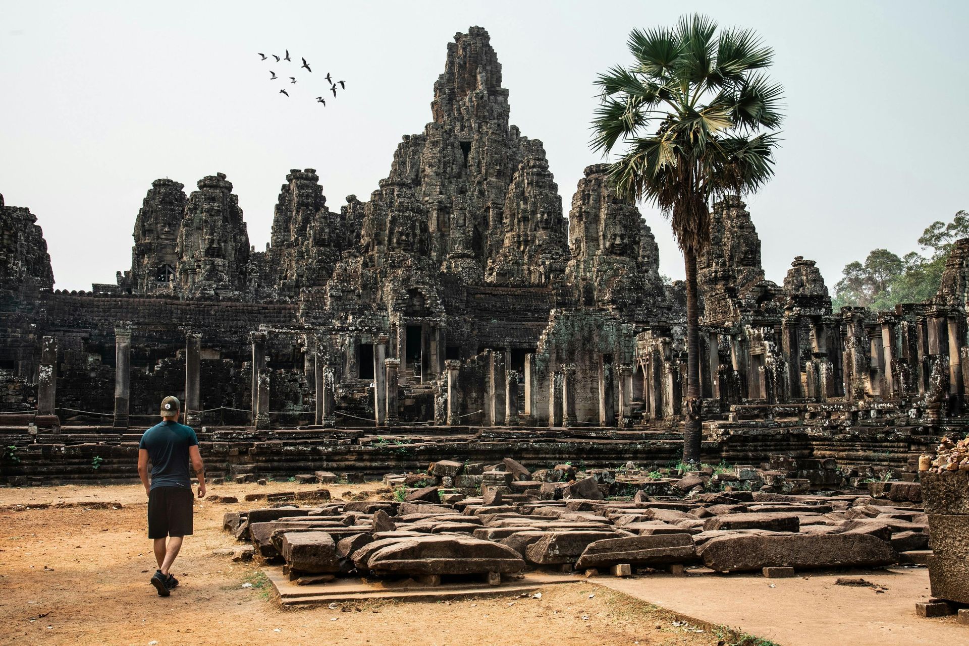 A man is walking through the ruins of the Banyon Temple at Angkor Wat in Cambodia.