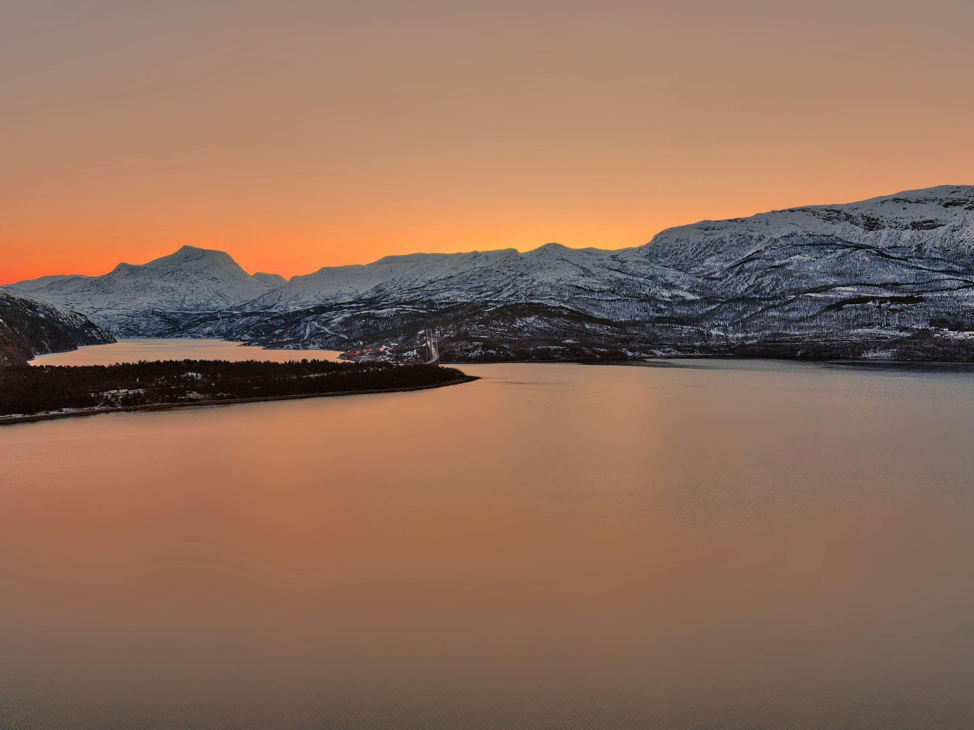 A lake with mountains in the background at sunset in Sweden.